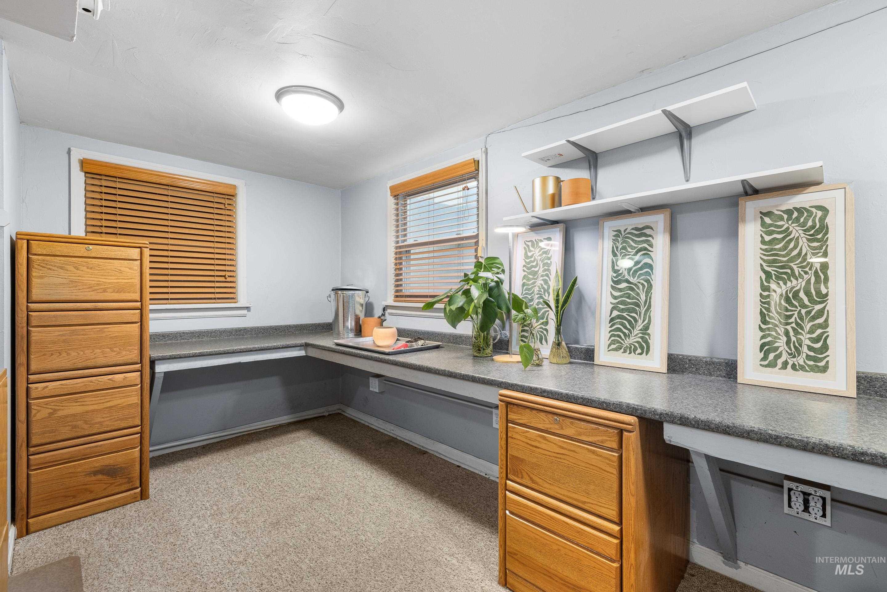 Unfurnished office featuring built in study area and light colored carpet