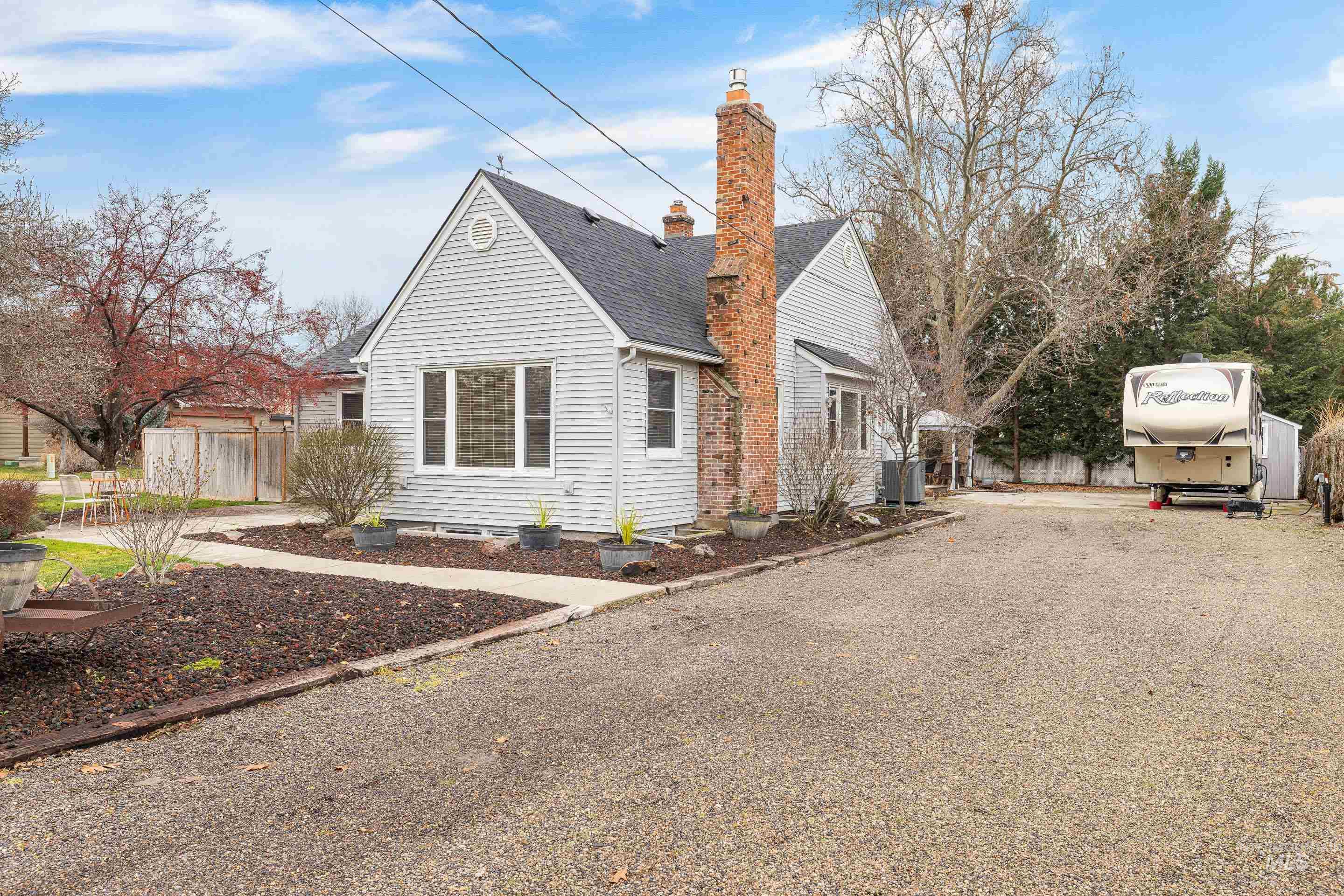 View of side of home featuring a chimney and roof with shingles