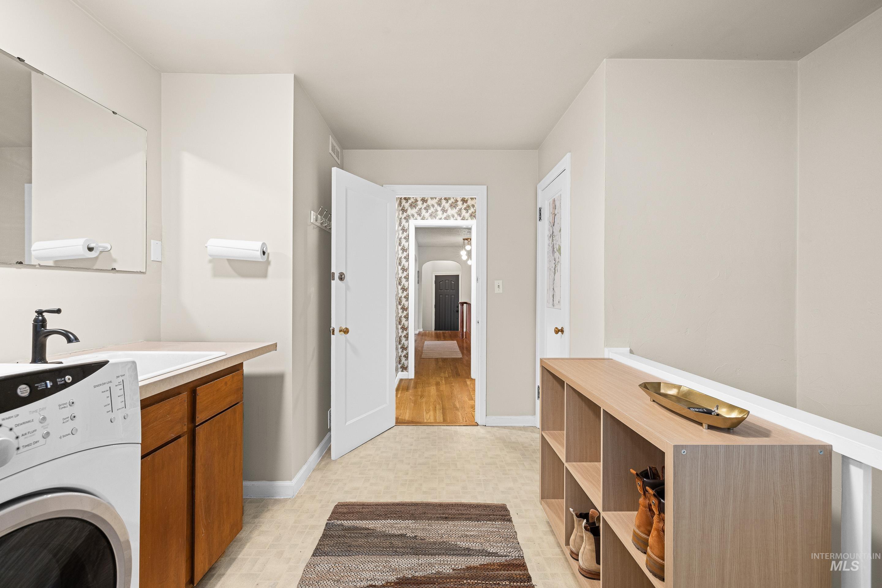 Laundry area with washer / dryer and light flooring