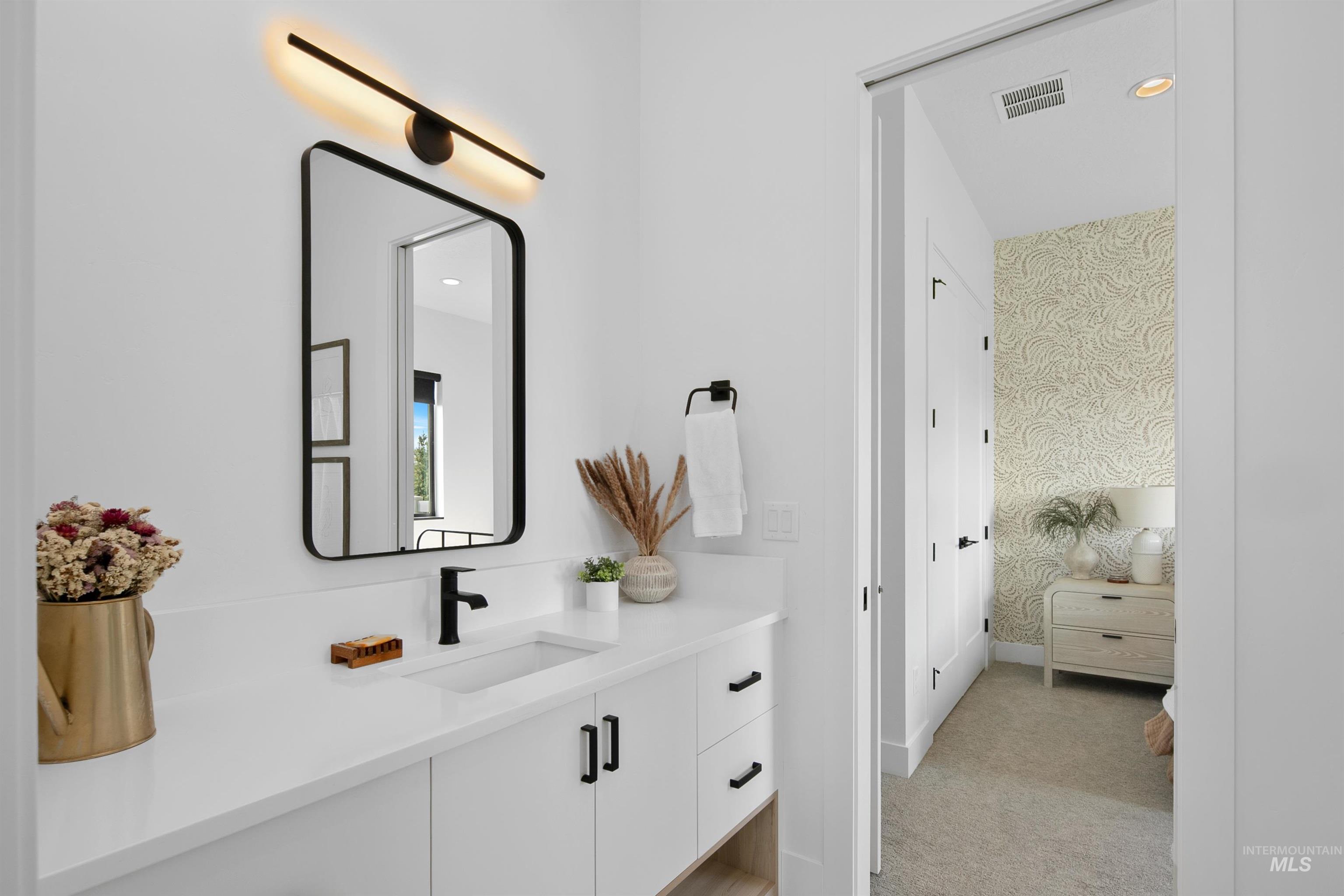 Bathroom with vanity, wallpapered walls, and recessed lighting