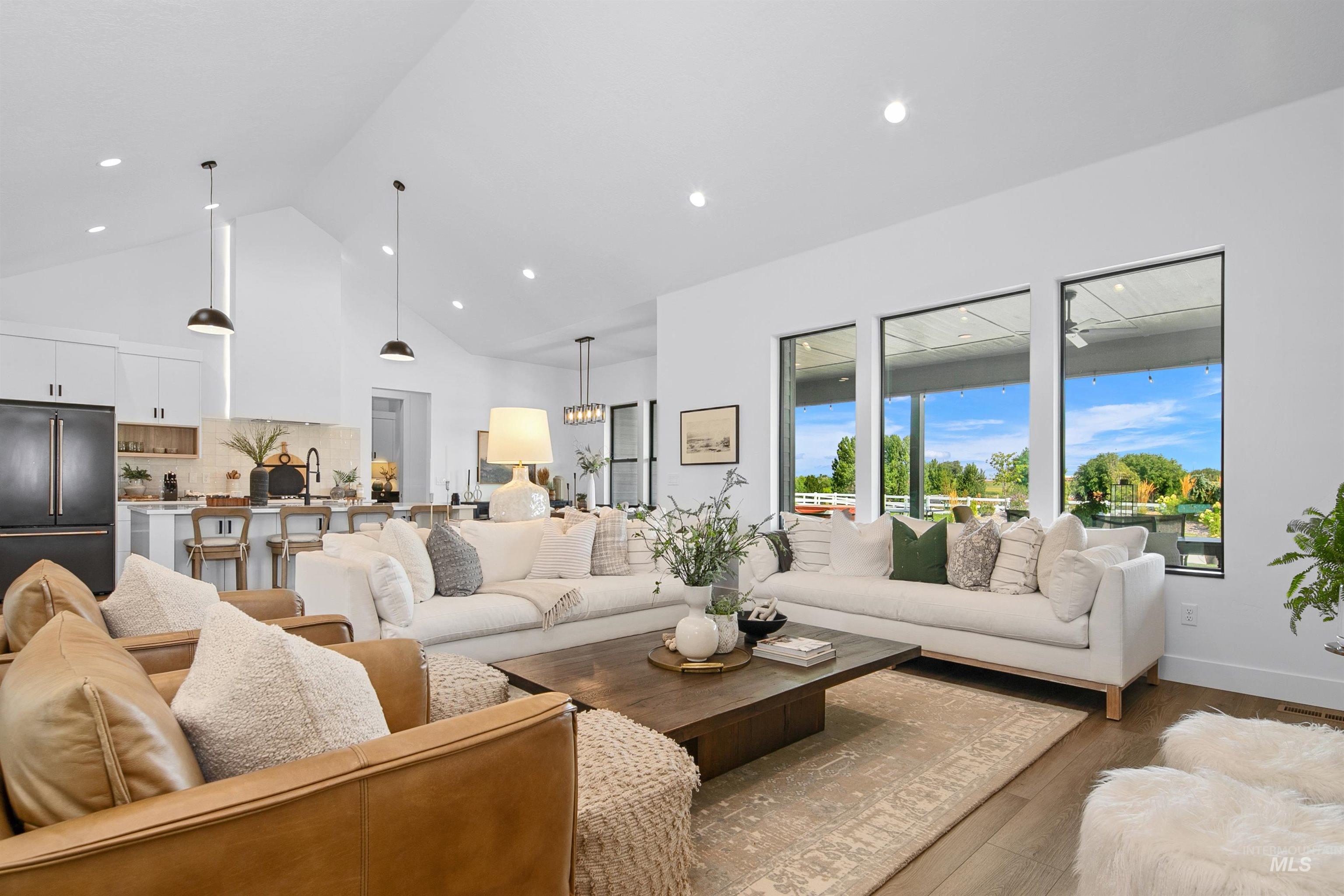 Living room featuring high vaulted ceiling, wood finished floors, and recessed lighting