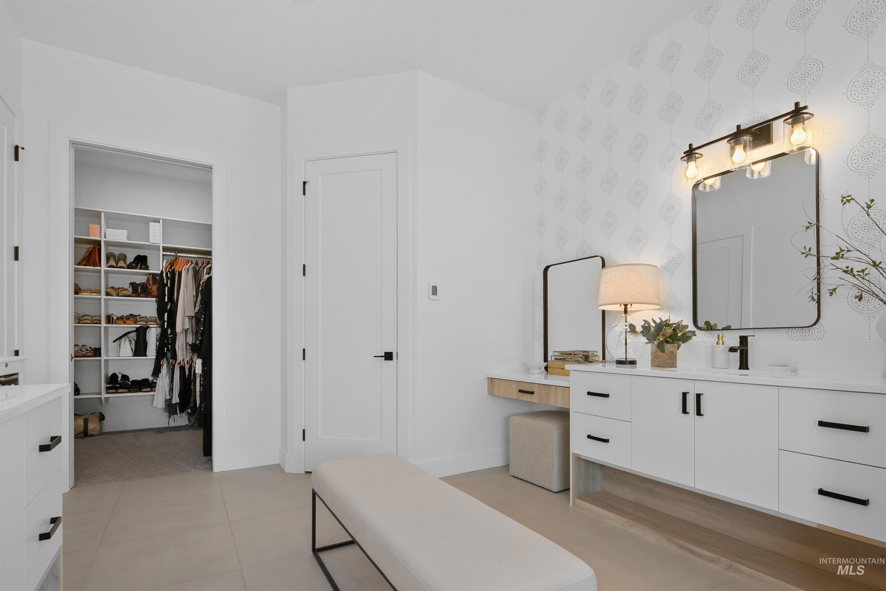 Bathroom featuring vanity, light tile patterned floors, and a spacious closet