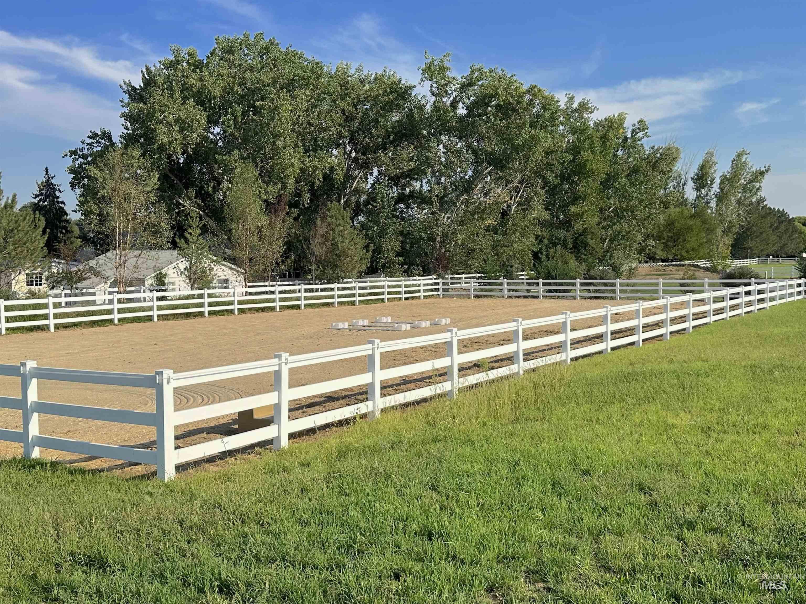 View of grassy yard with an enclosed horse arena and a rural view