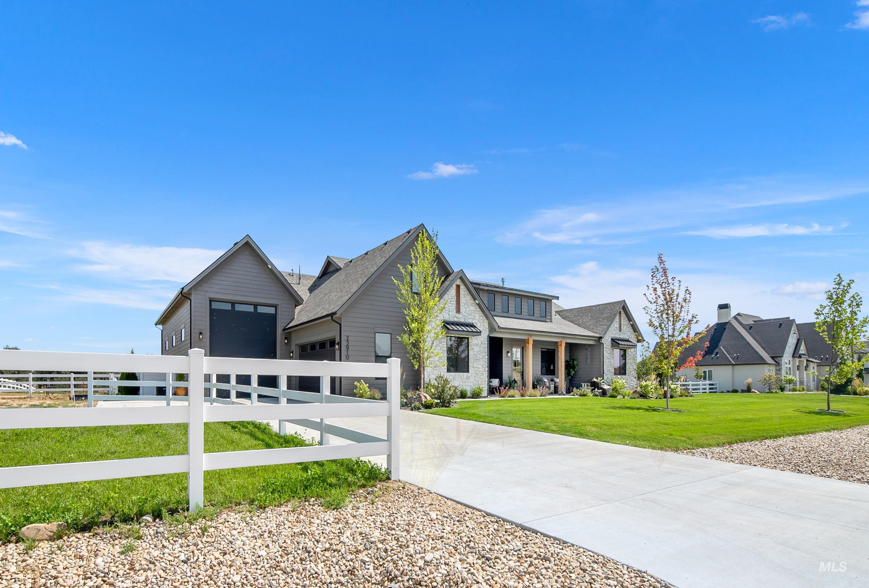 View of front of house featuring a garage, driveway, and covered porch