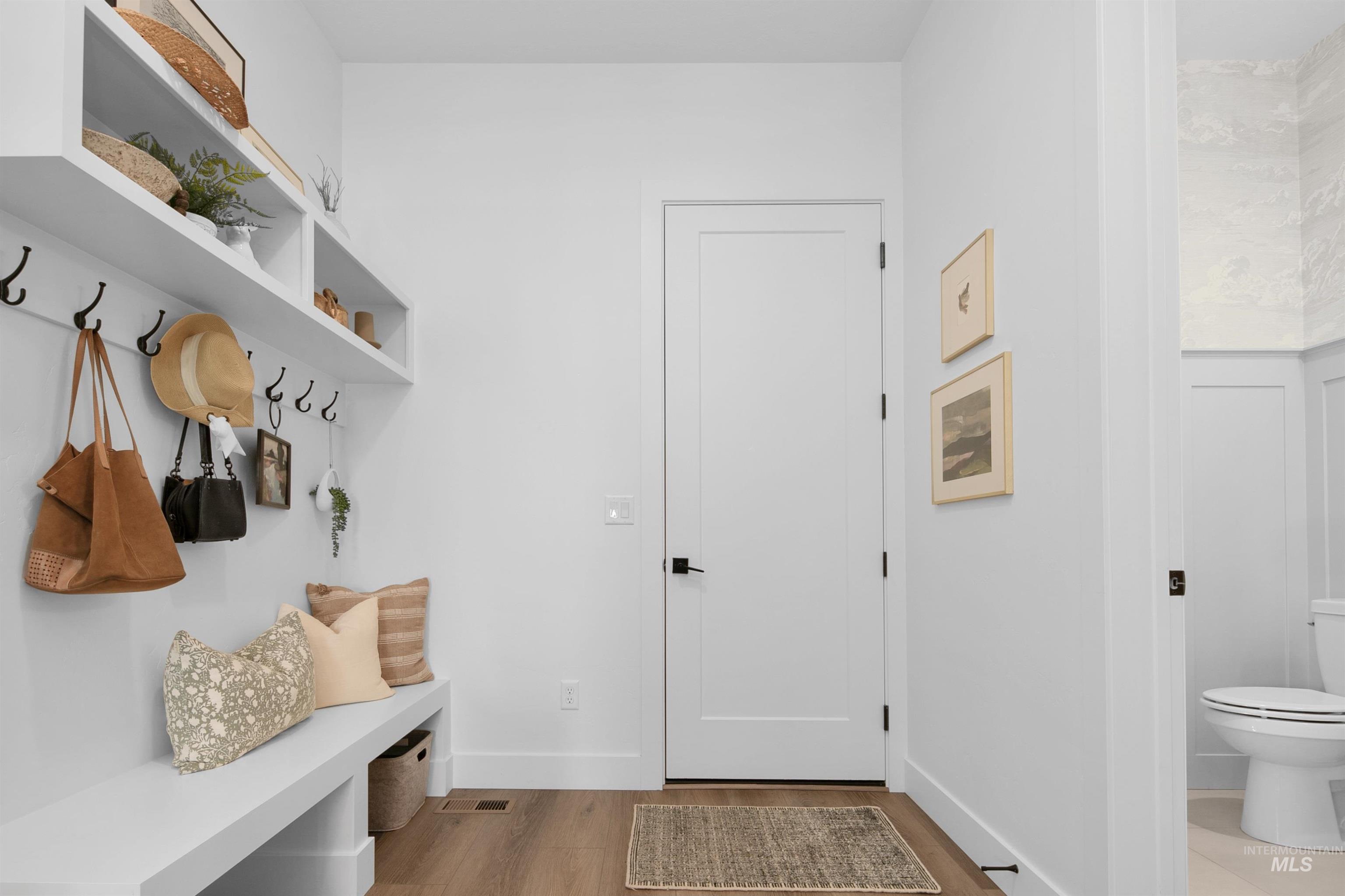 Mudroom with wood finished floors and baseboards