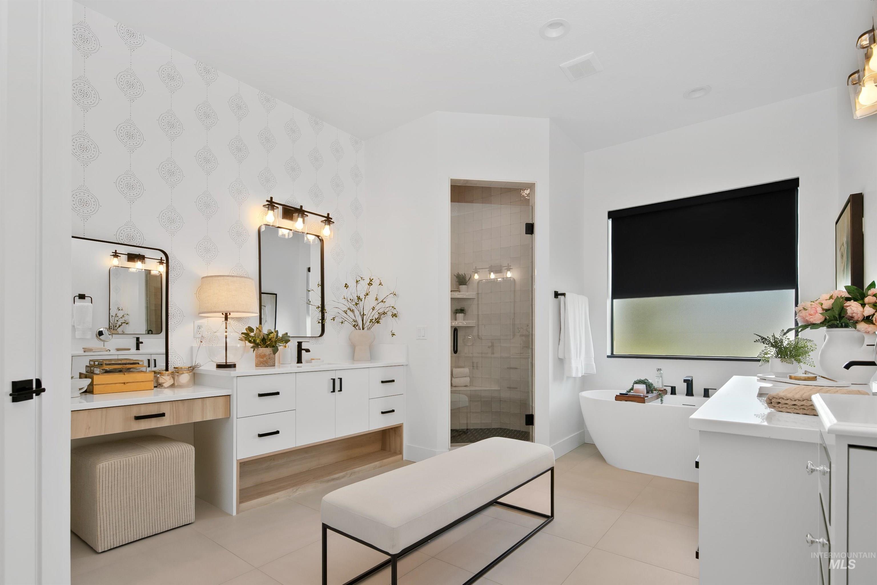 Full bath featuring walk in shower, vanity, a freestanding tub, light tile patterned floors, and wallpapered walls