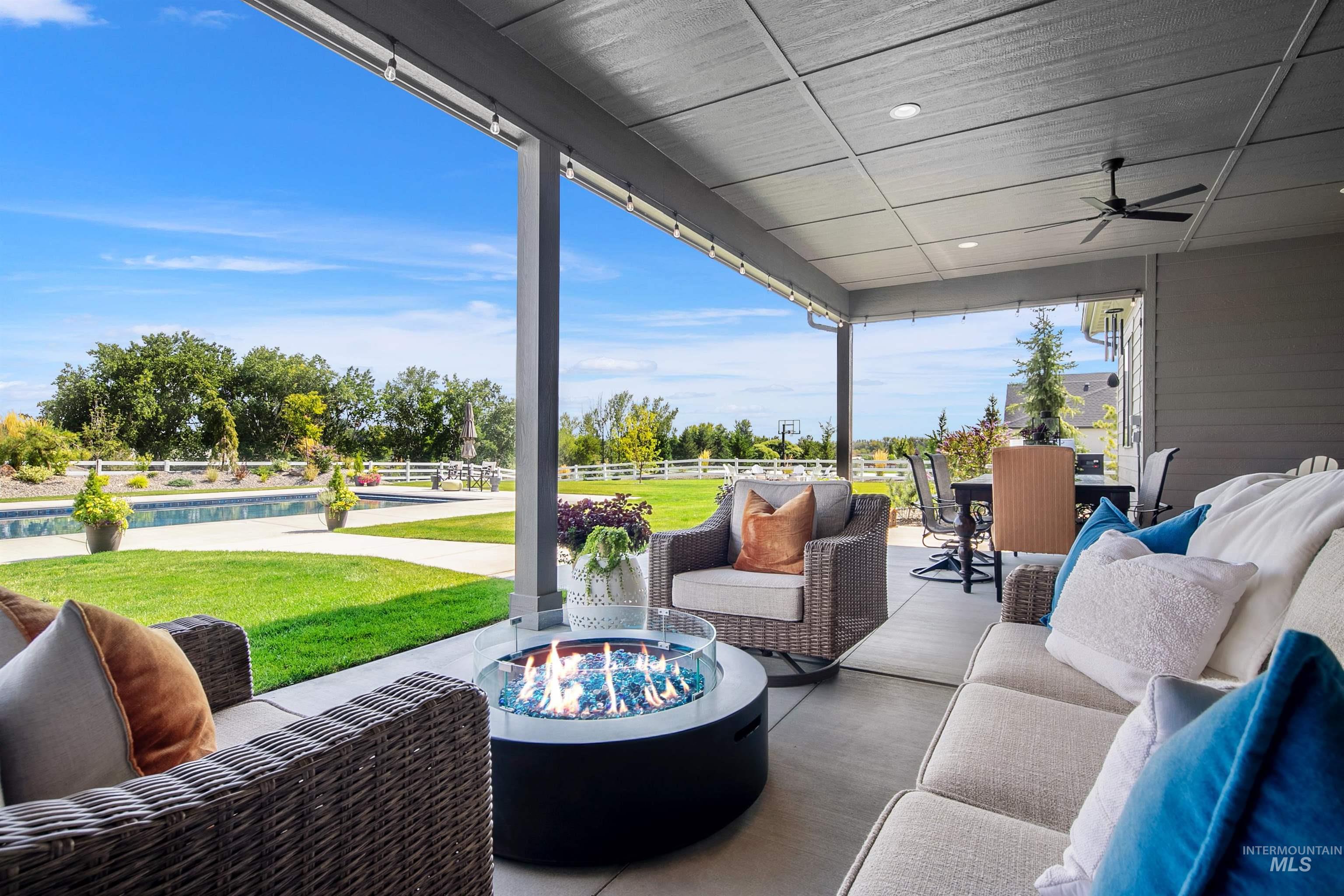 View of patio featuring an outdoor living space with a fire pit, ceiling fan, and an outdoor pool