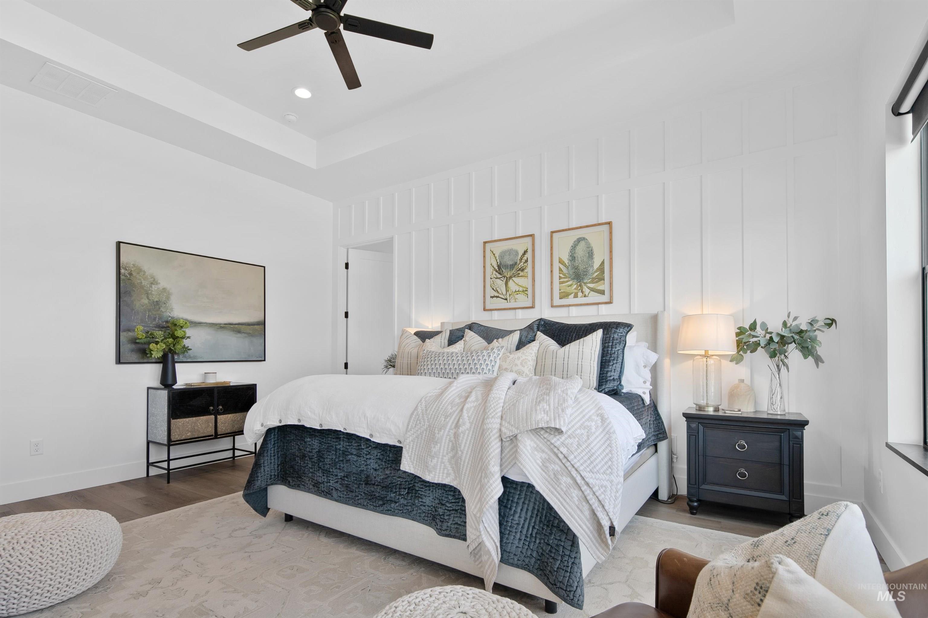 Bedroom with a ceiling fan, wood finished floors, a raised ceiling, and recessed lighting