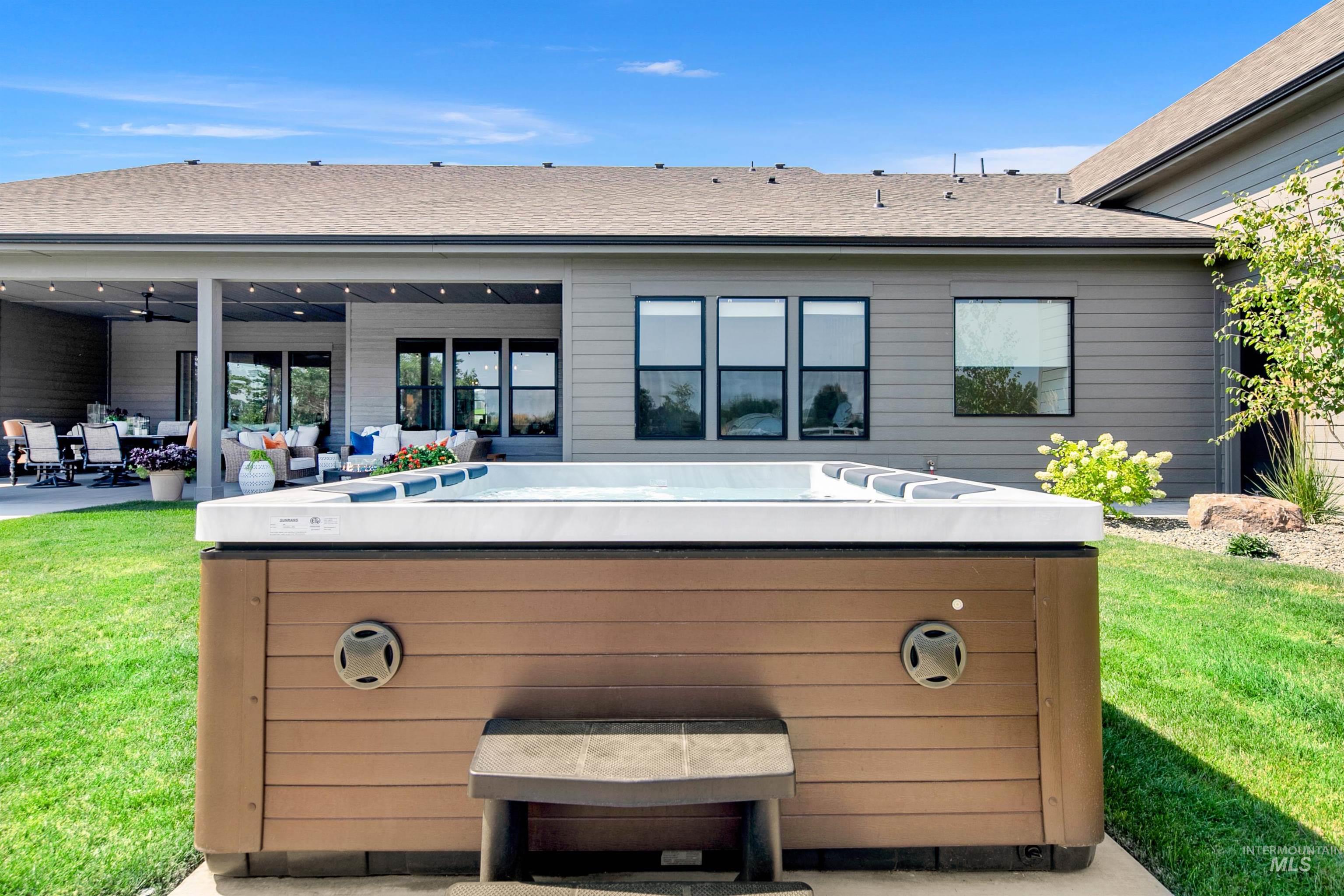 View of patio / terrace featuring a hot tub, outdoor lounge area, and a ceiling fan