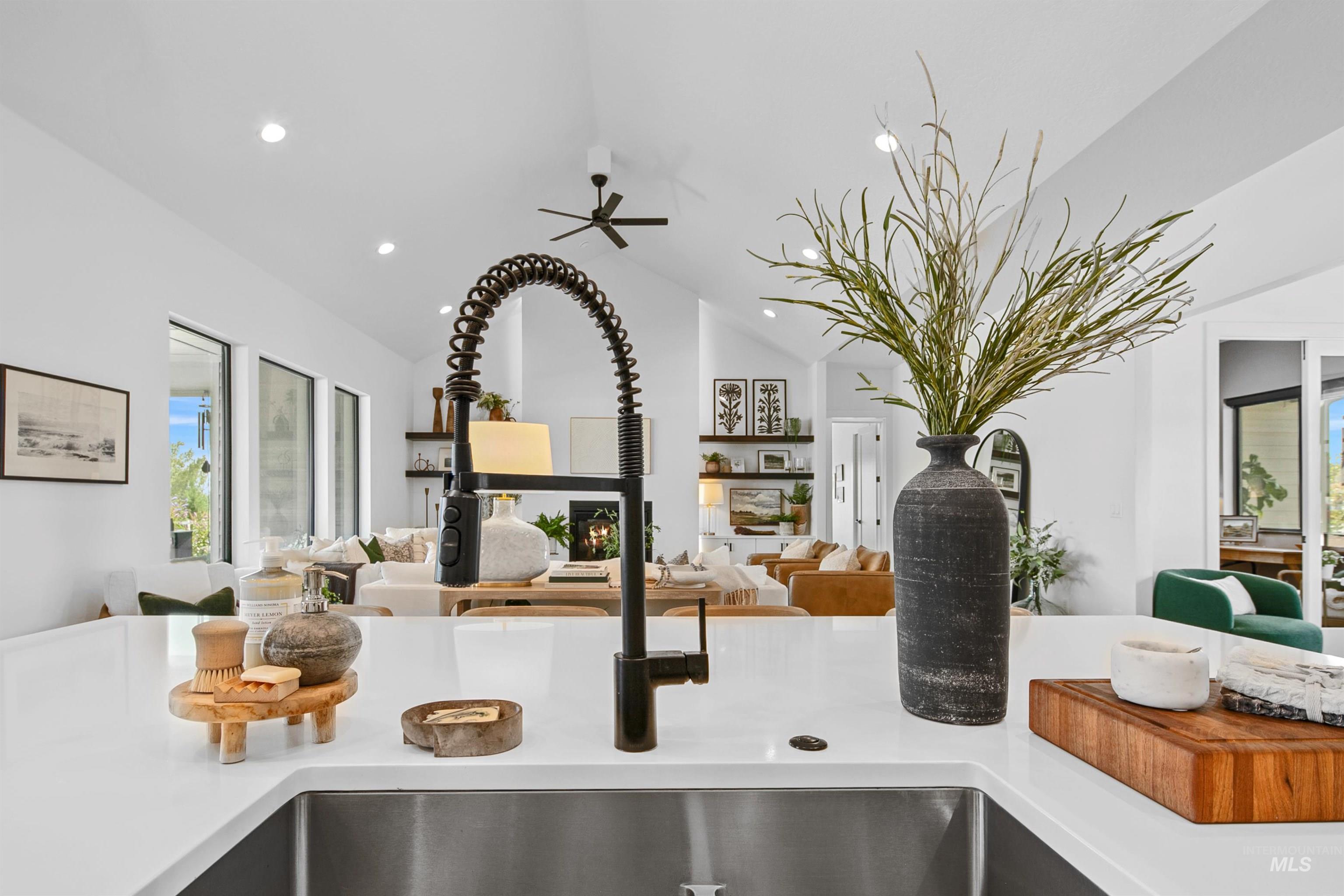 Kitchen view of recessed lighting, a ceiling fan, and light stone counters