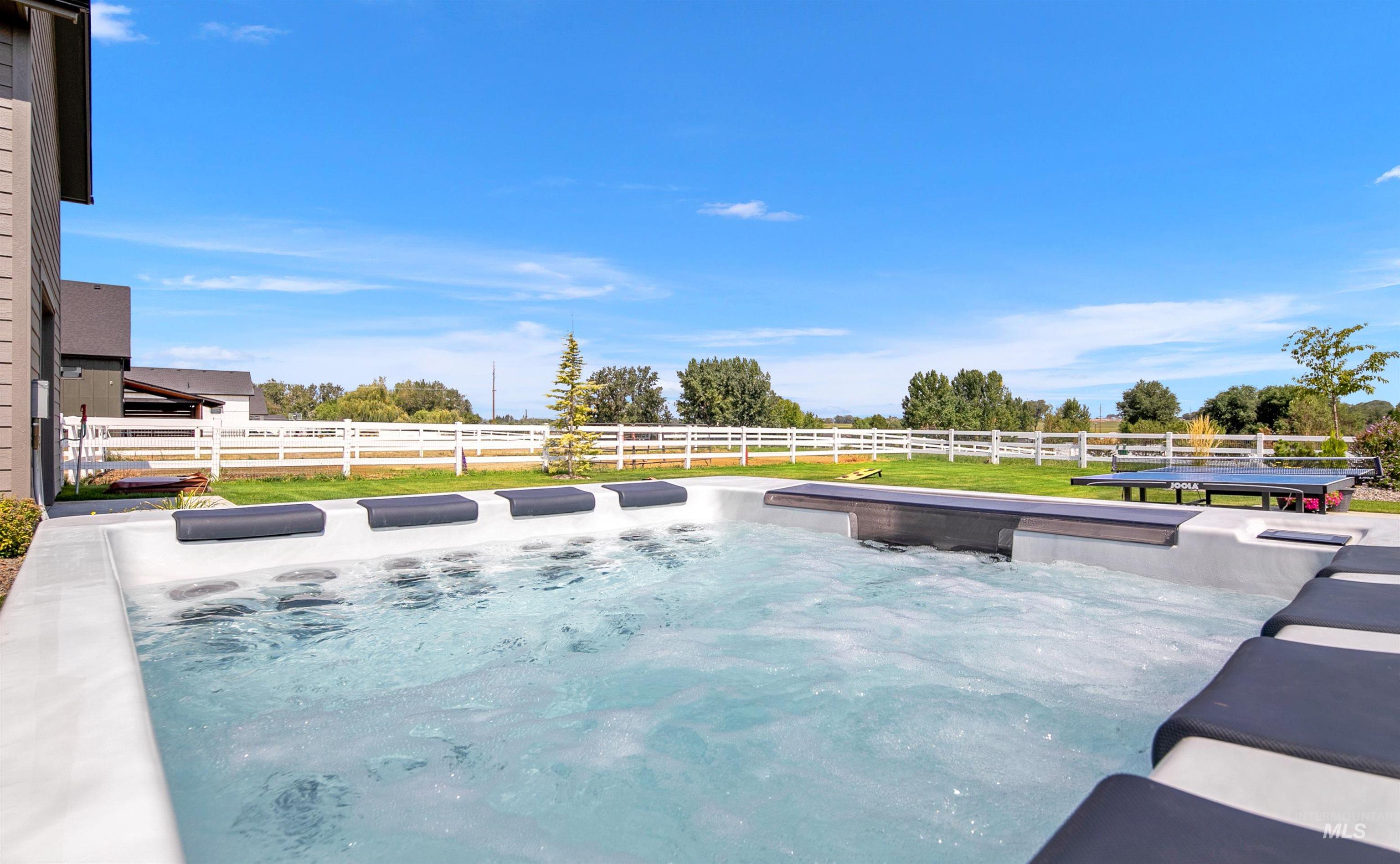 View of pool with a hot tub