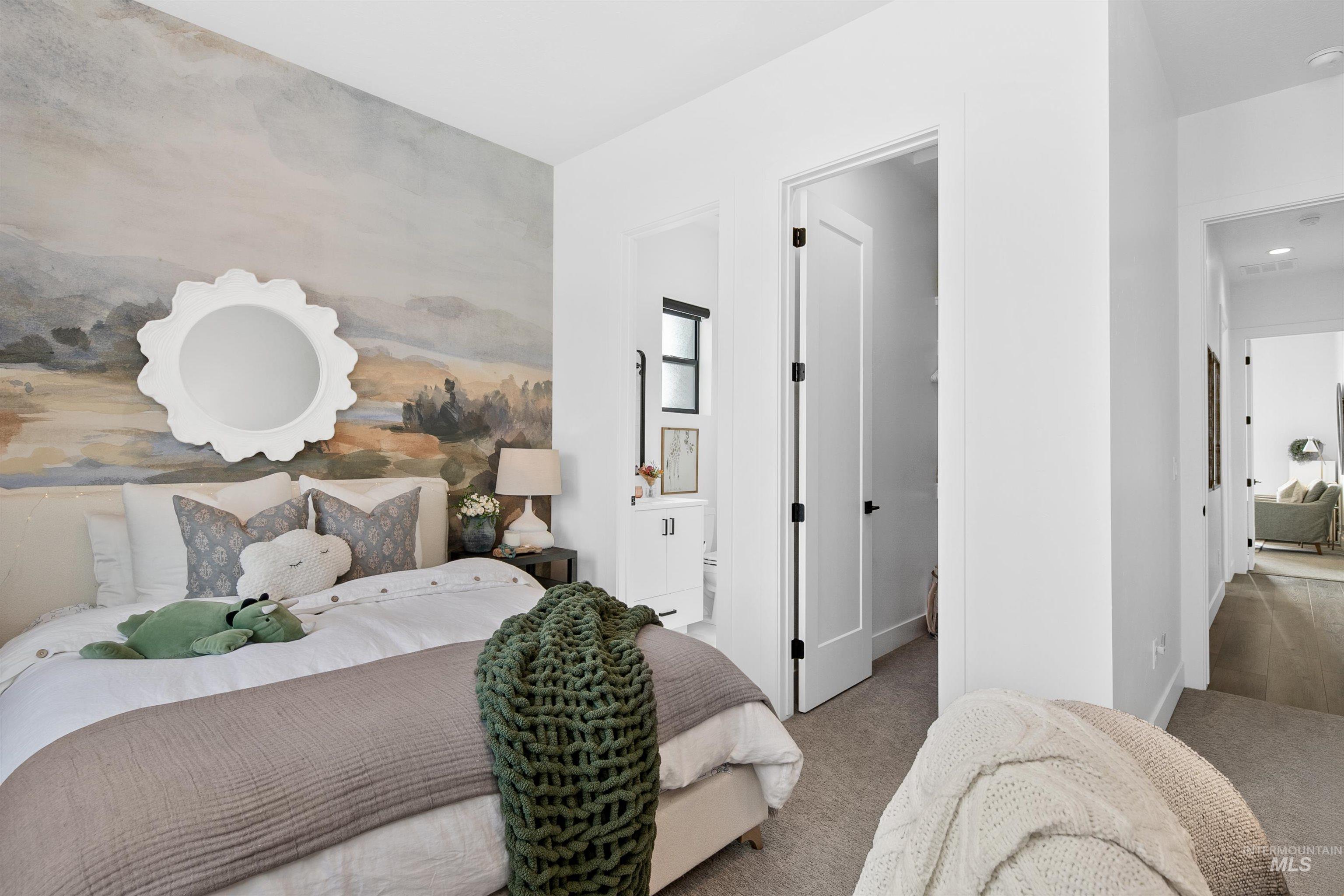 Carpeted bedroom featuring ensuite bathroom and baseboards