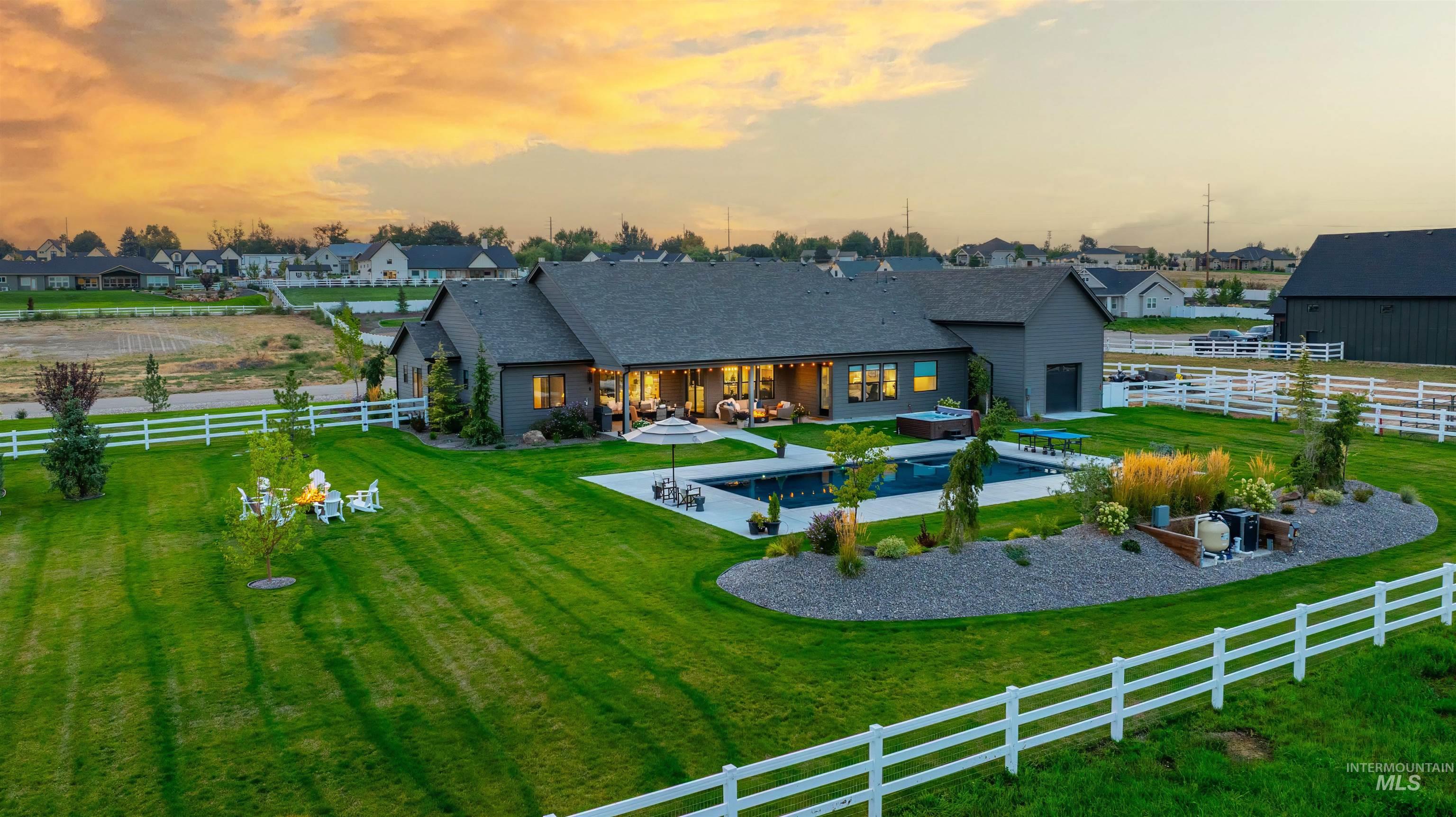 Back of property with a fenced backyard, a patio, an outdoor pool, a residential view, and a shingled roof