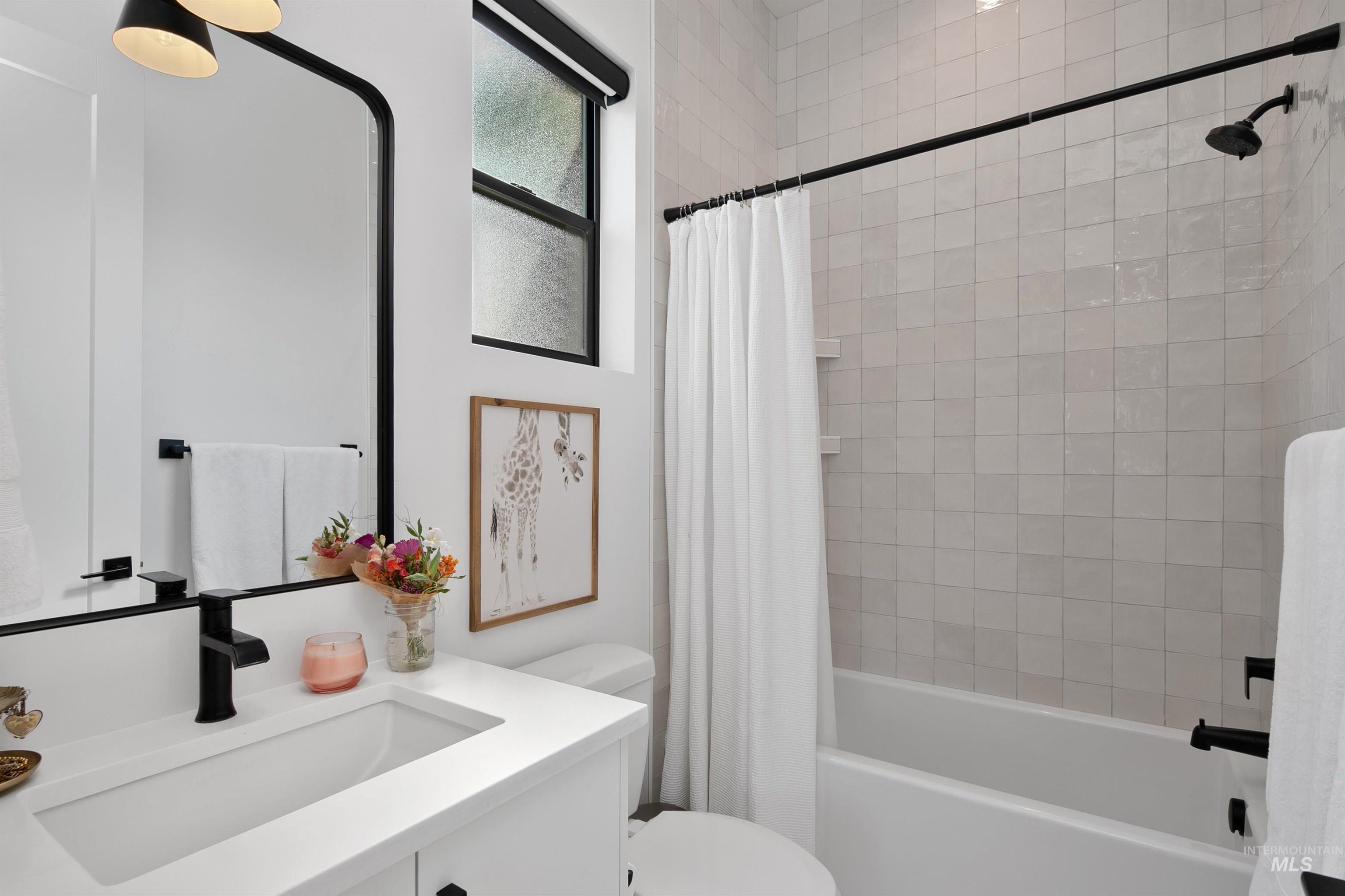 Bathroom featuring shower / bathtub combination with curtain and vanity