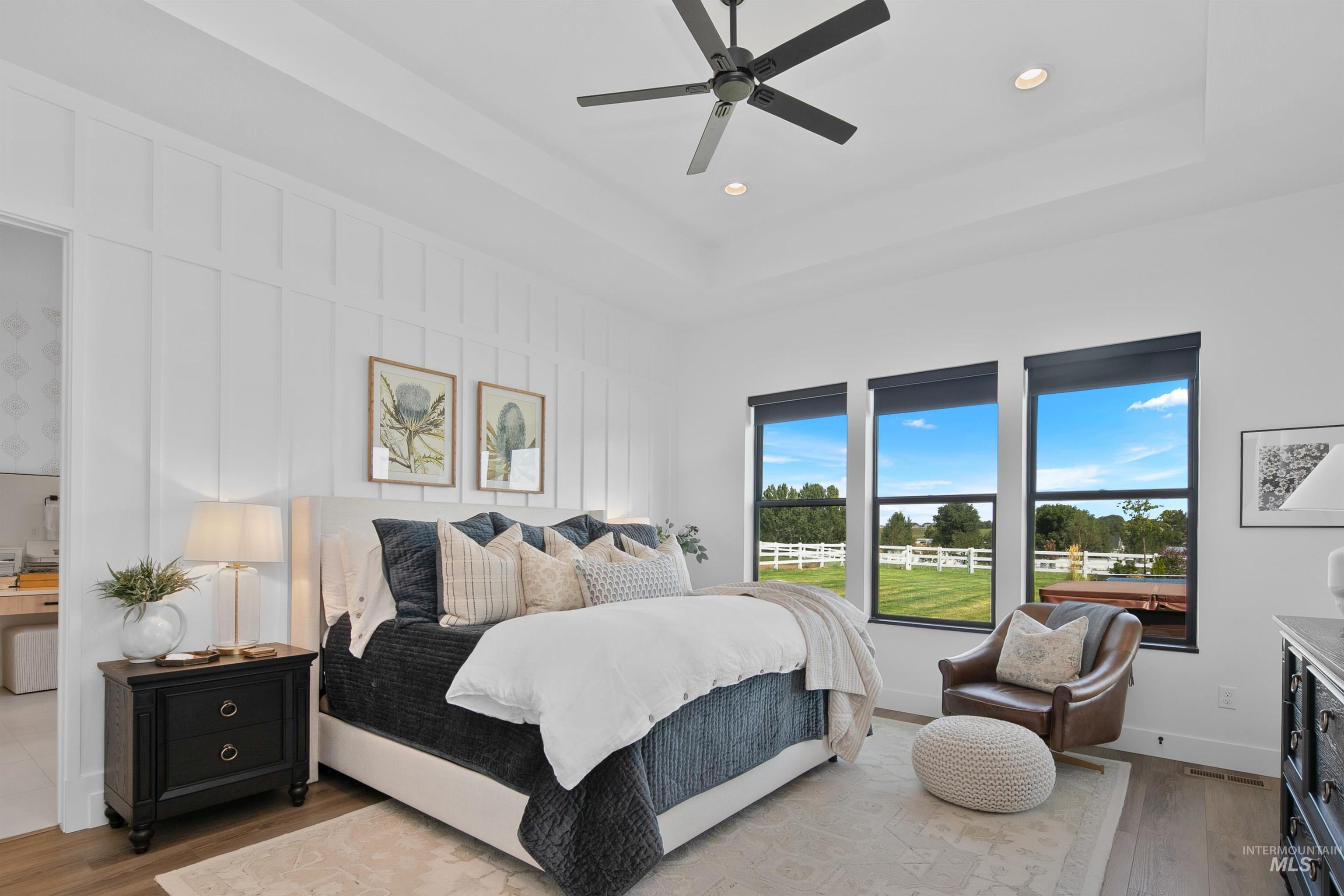 Bedroom featuring a tray ceiling, light wood-type flooring, a ceiling fan, and recessed lighting