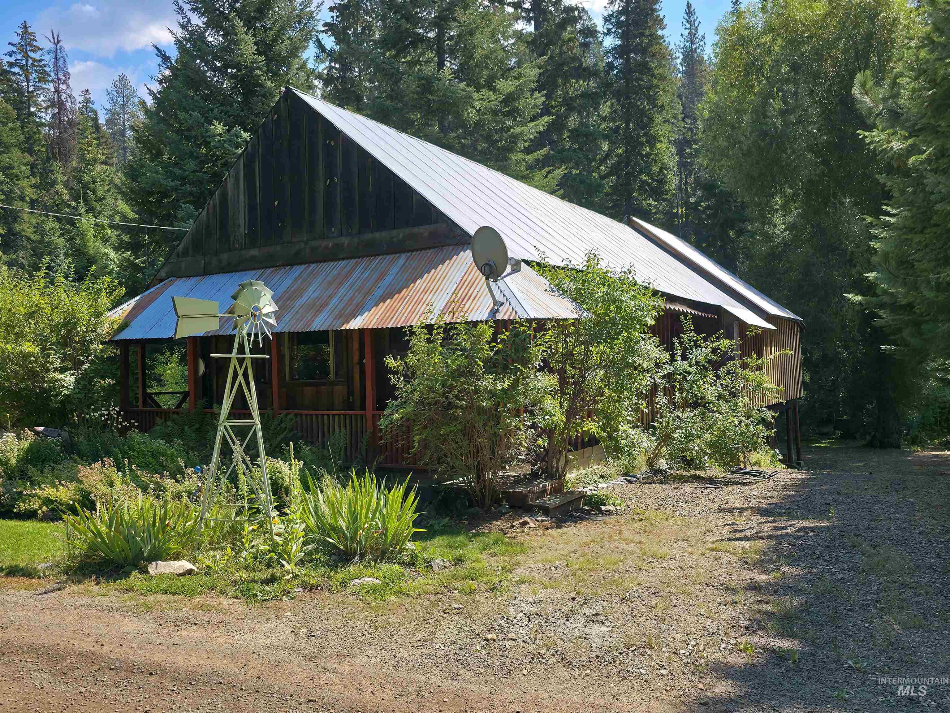 Chalet / cabin with a wooded view, a porch, and a metal roof