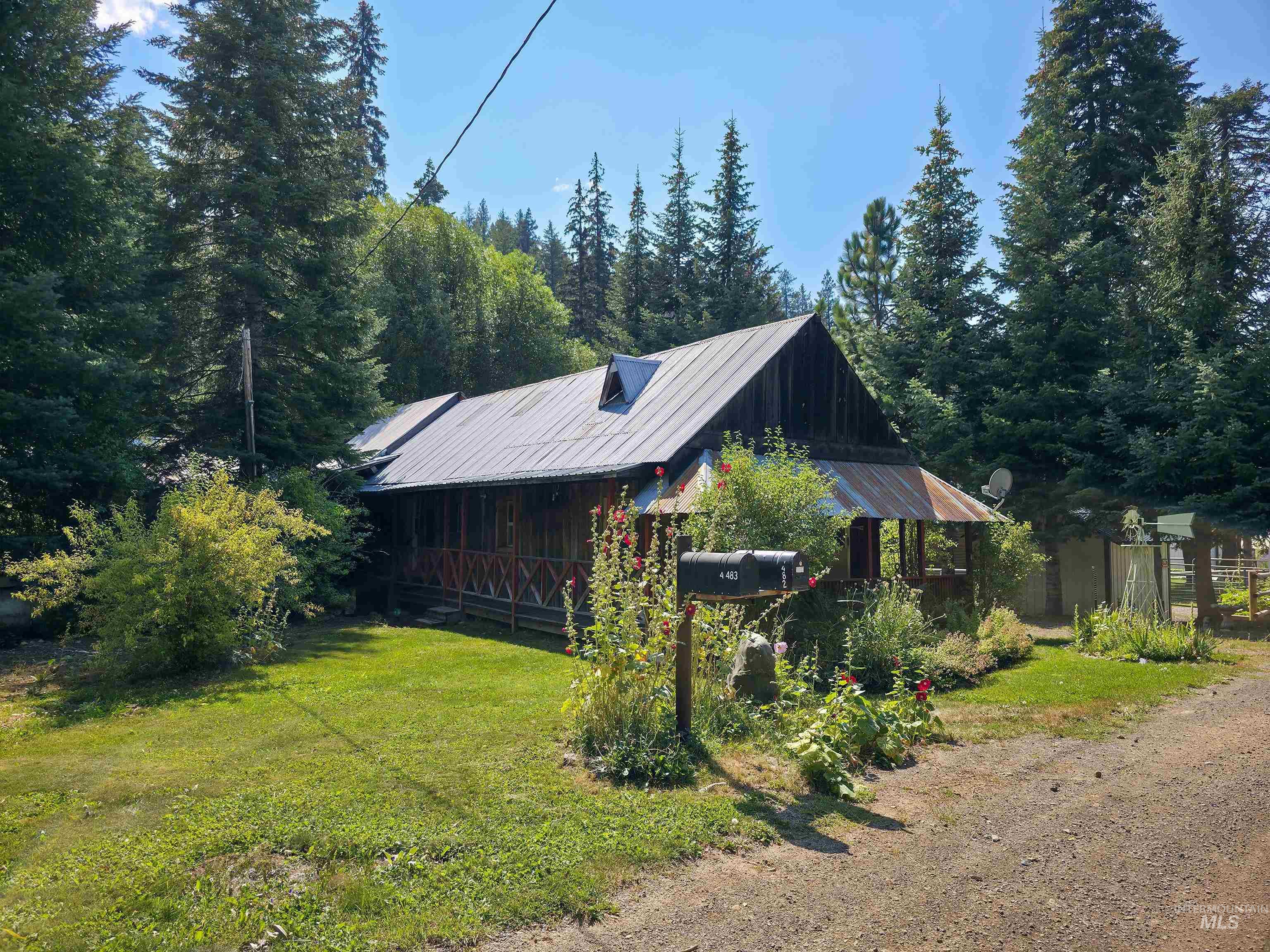 View of front facade featuring a metal roof and a front lawn