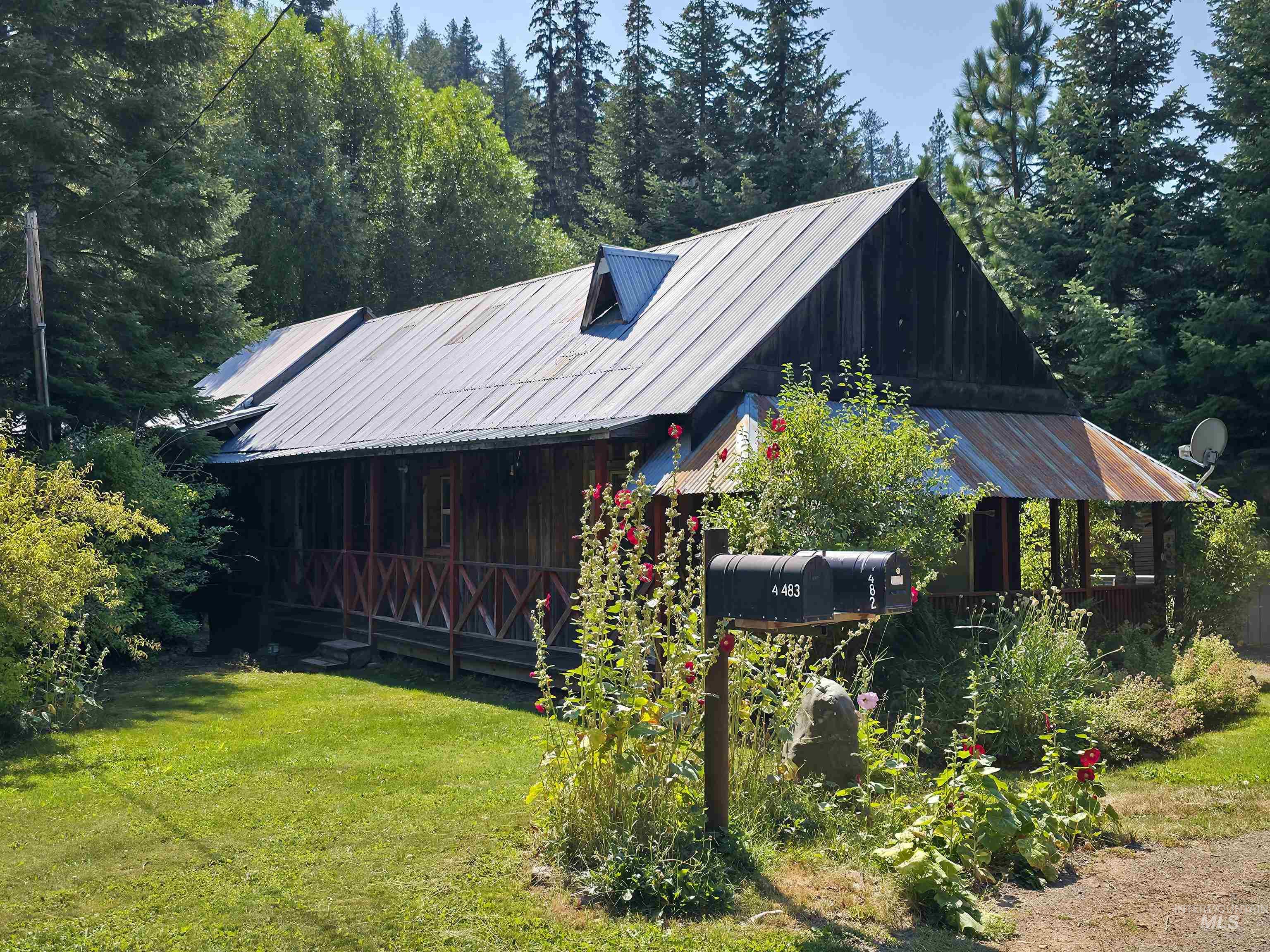 View of front of property with a metal roof and a front lawn