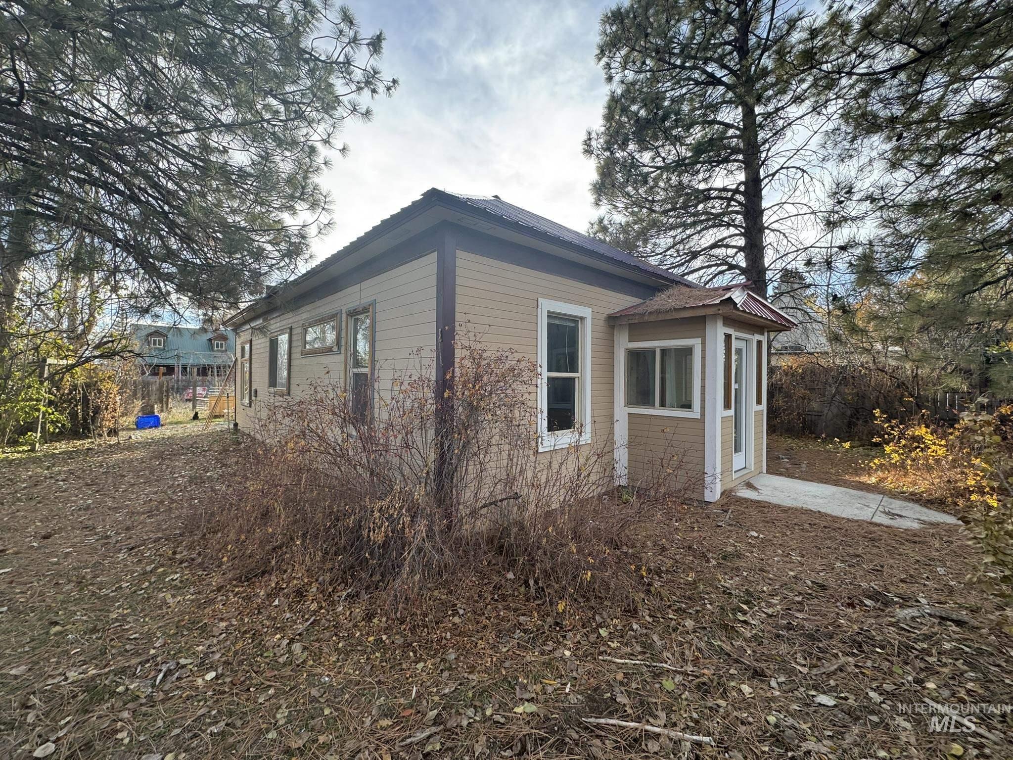 View of side of home with a sunroom and a metal roof