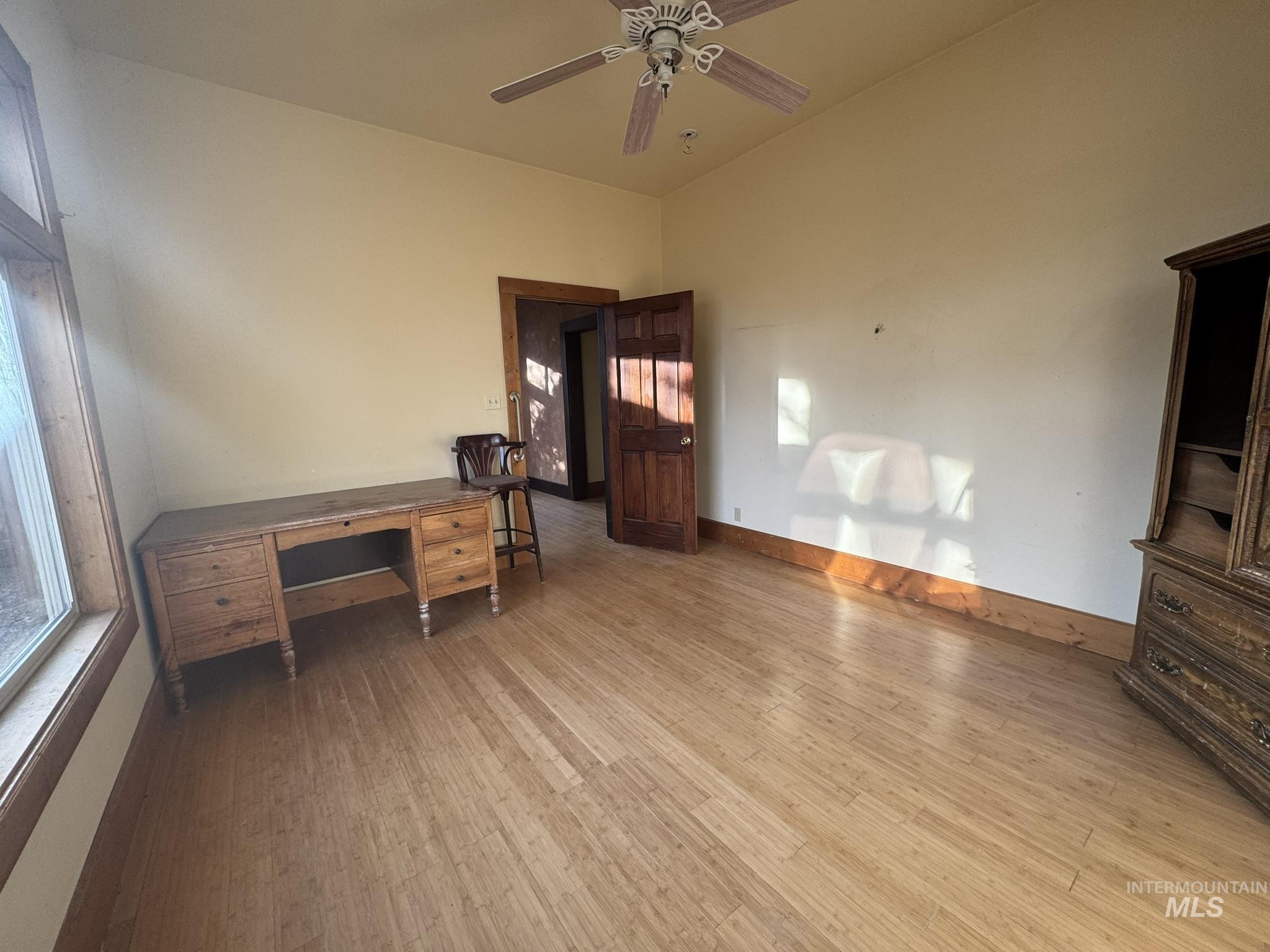 Unfurnished office with light wood-style floors and ceiling fan