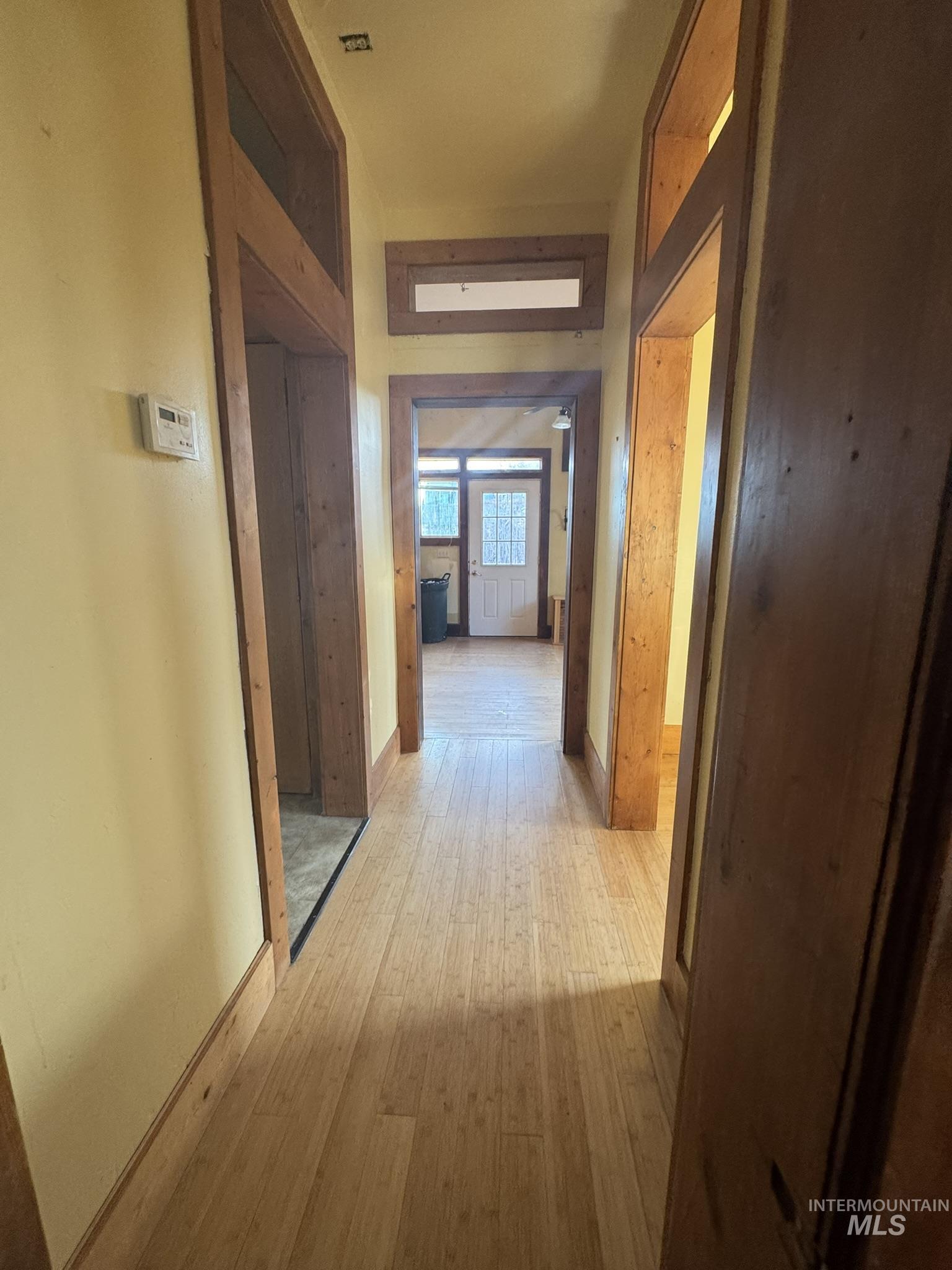 Hallway featuring wood finished floors and baseboards