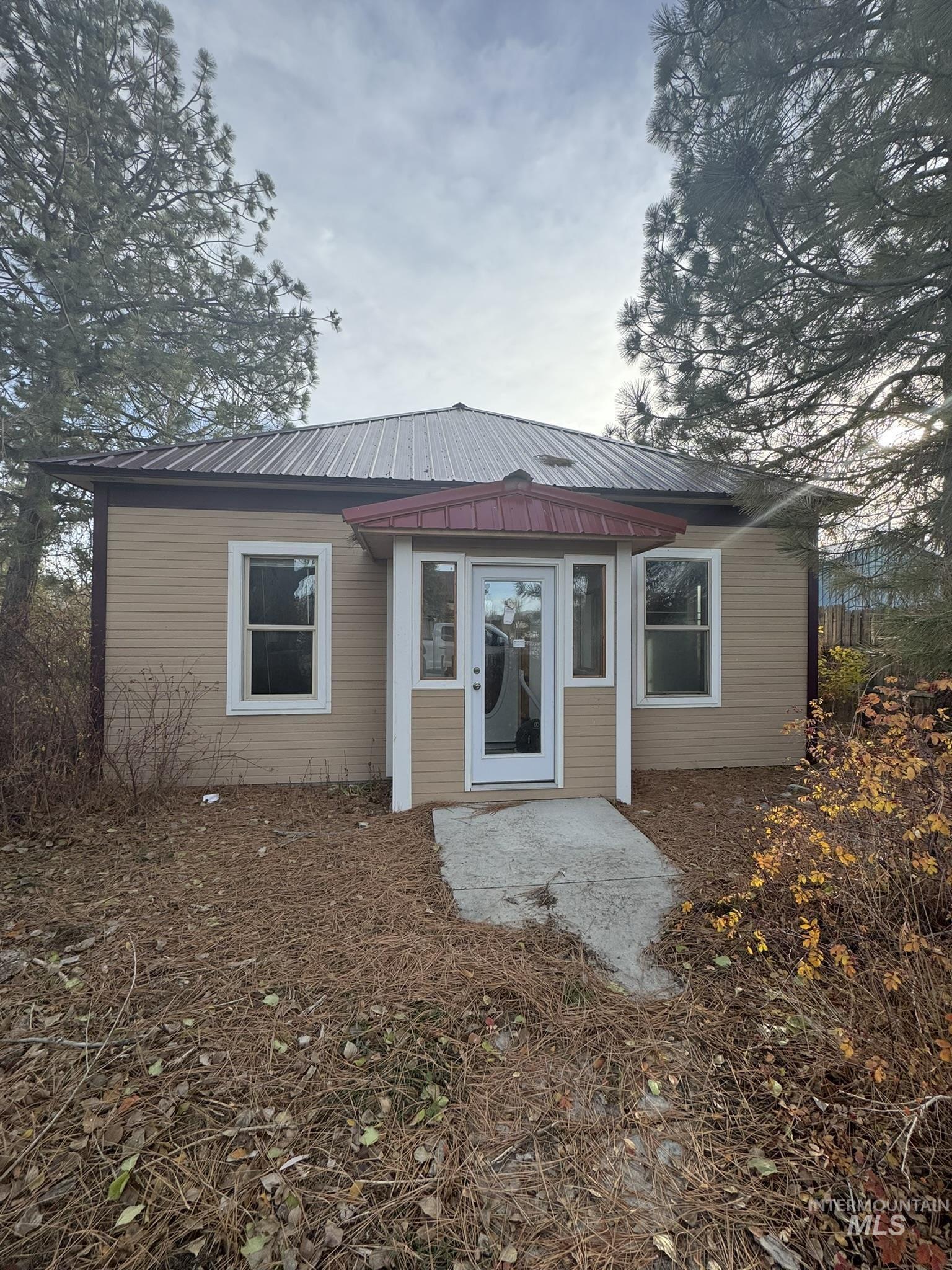 Back of property with a metal roof and a patio area