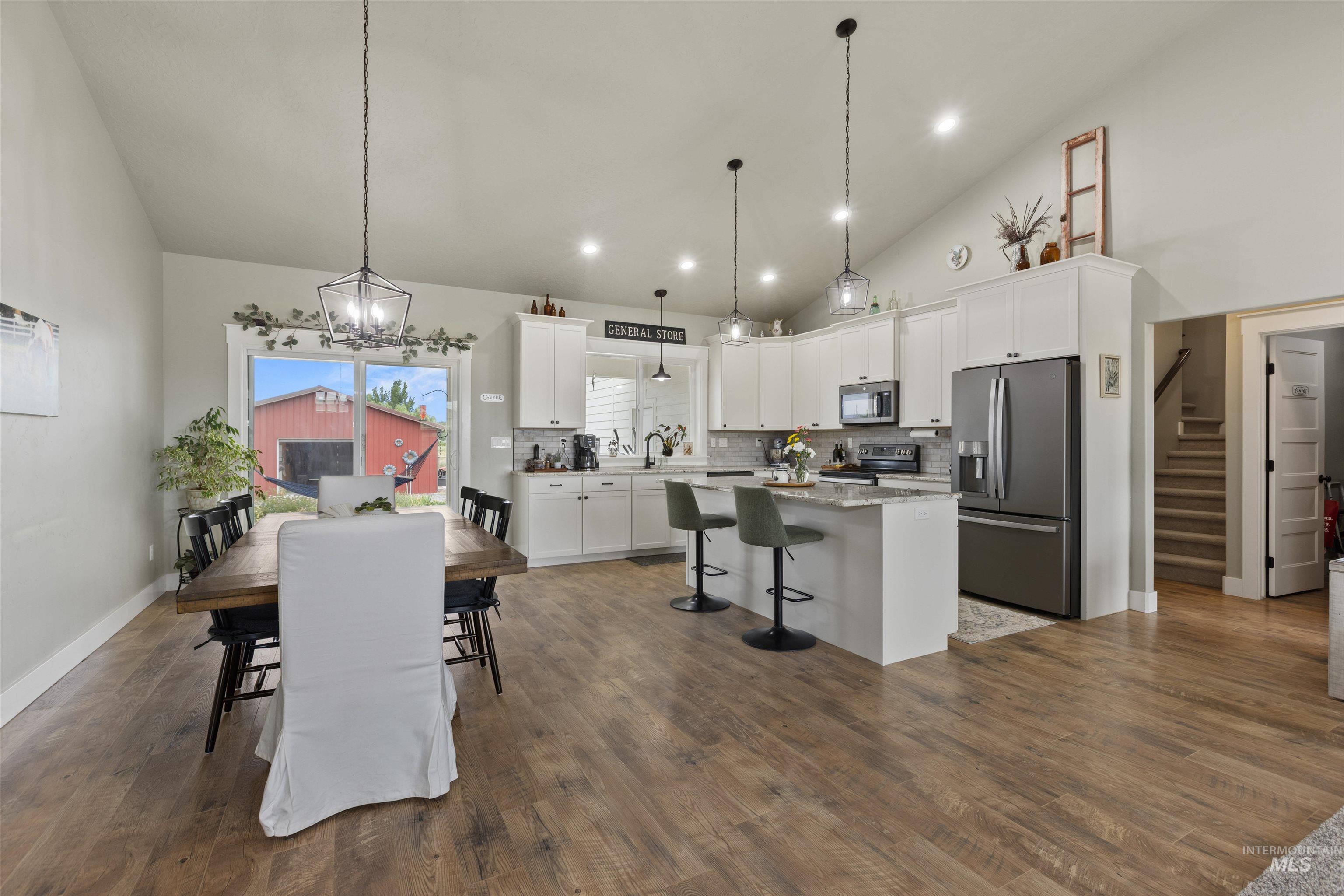 Kitchen with stainless steel appliances, a center island, white cabinetry, a kitchen bar, and decorative backsplash