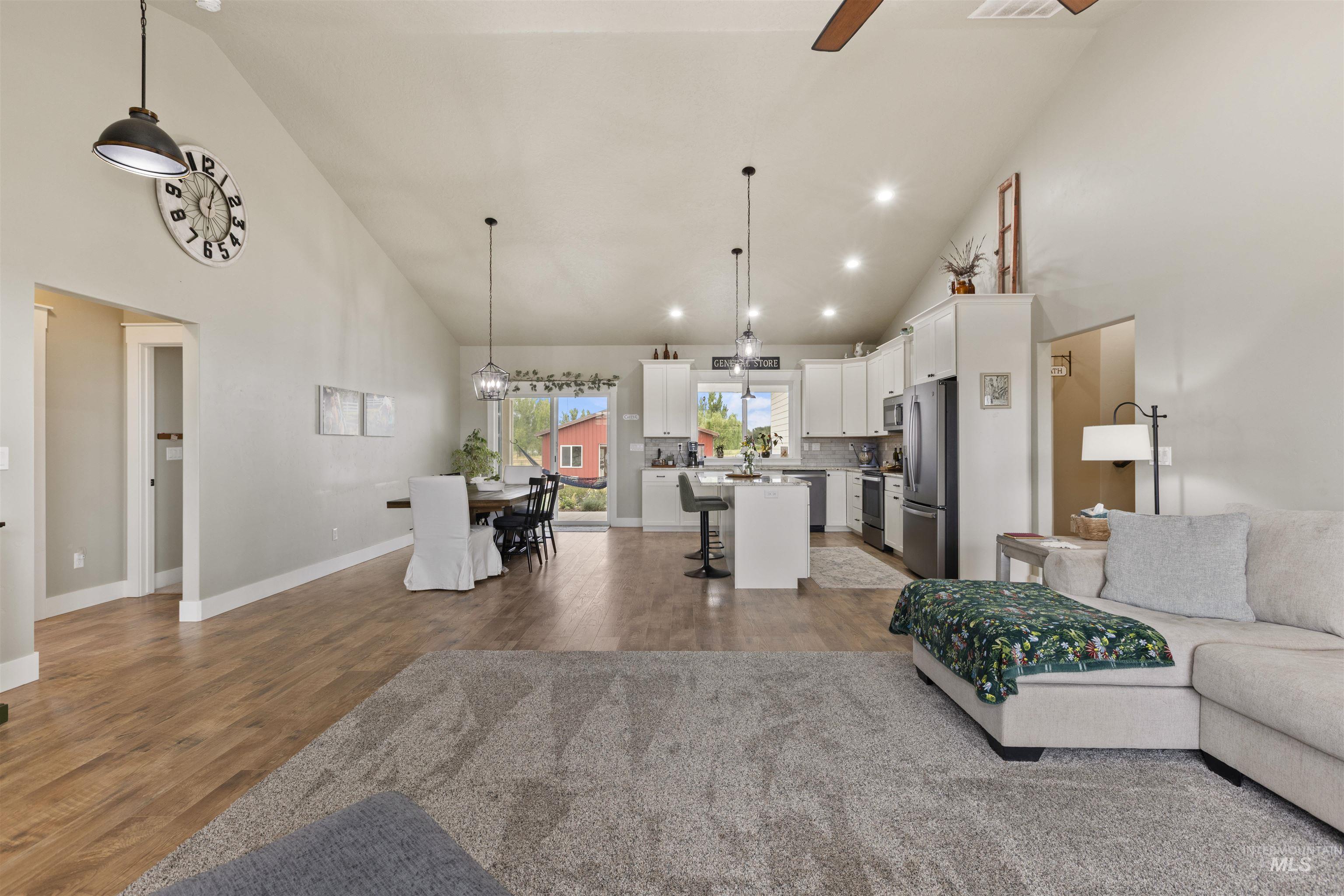 Living room featuring a ceiling fan, high vaulted ceiling, wood finished floors, and recessed lighting