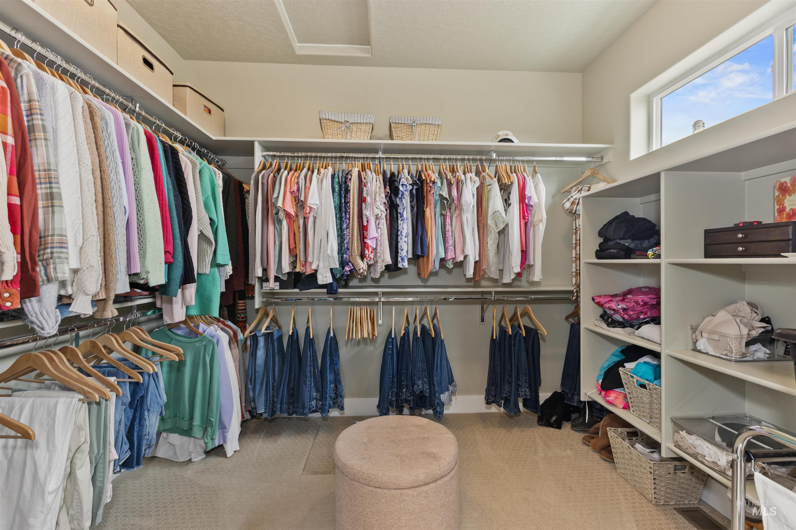 Walk in closet featuring attic access and carpet floors