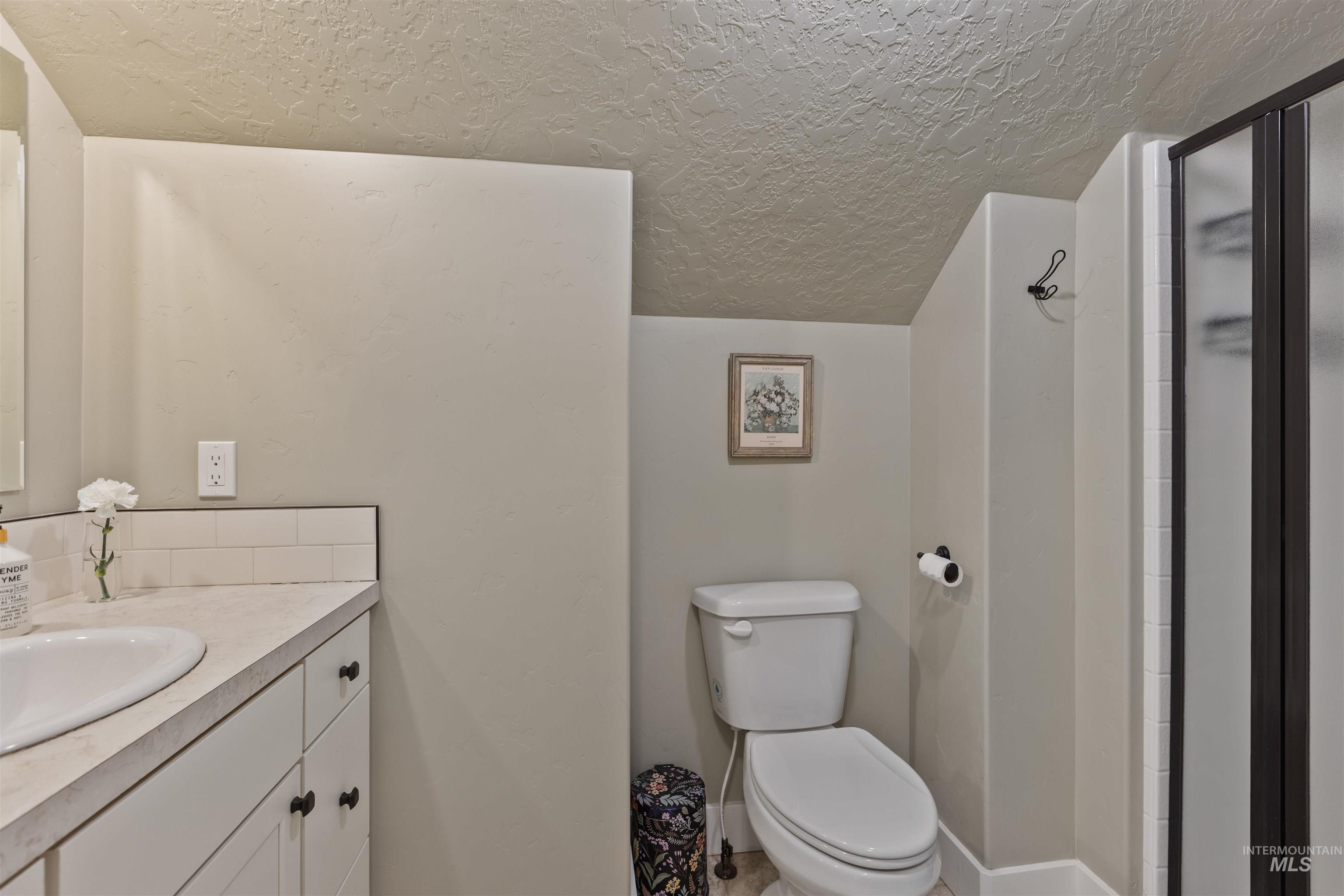 Bonus Rm Bathroom with a textured ceiling, vanity, and a shower stall