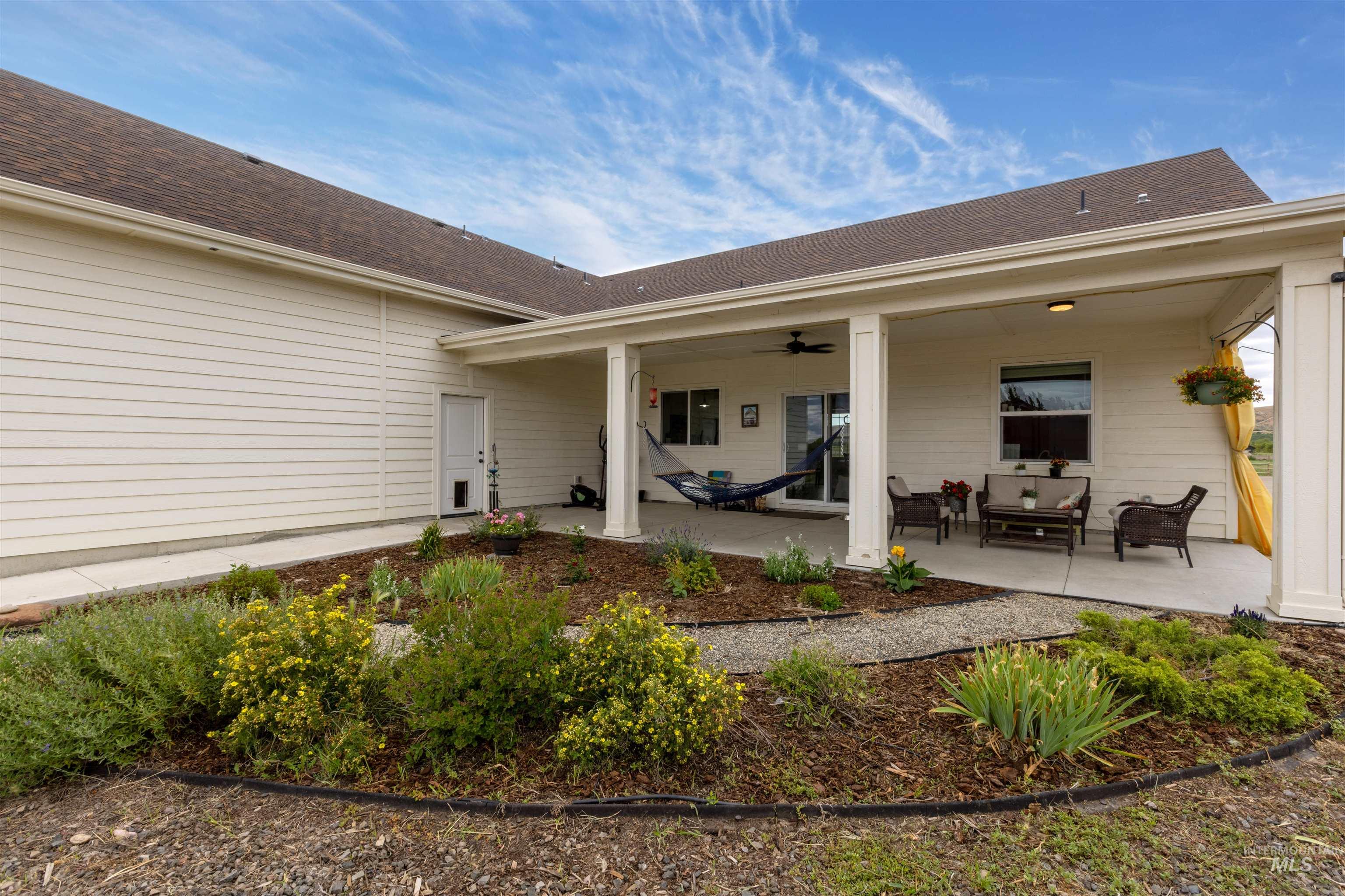 Rear view of house featuring outdoor lounge area, a shingled roof, a ceiling fan, and a patio