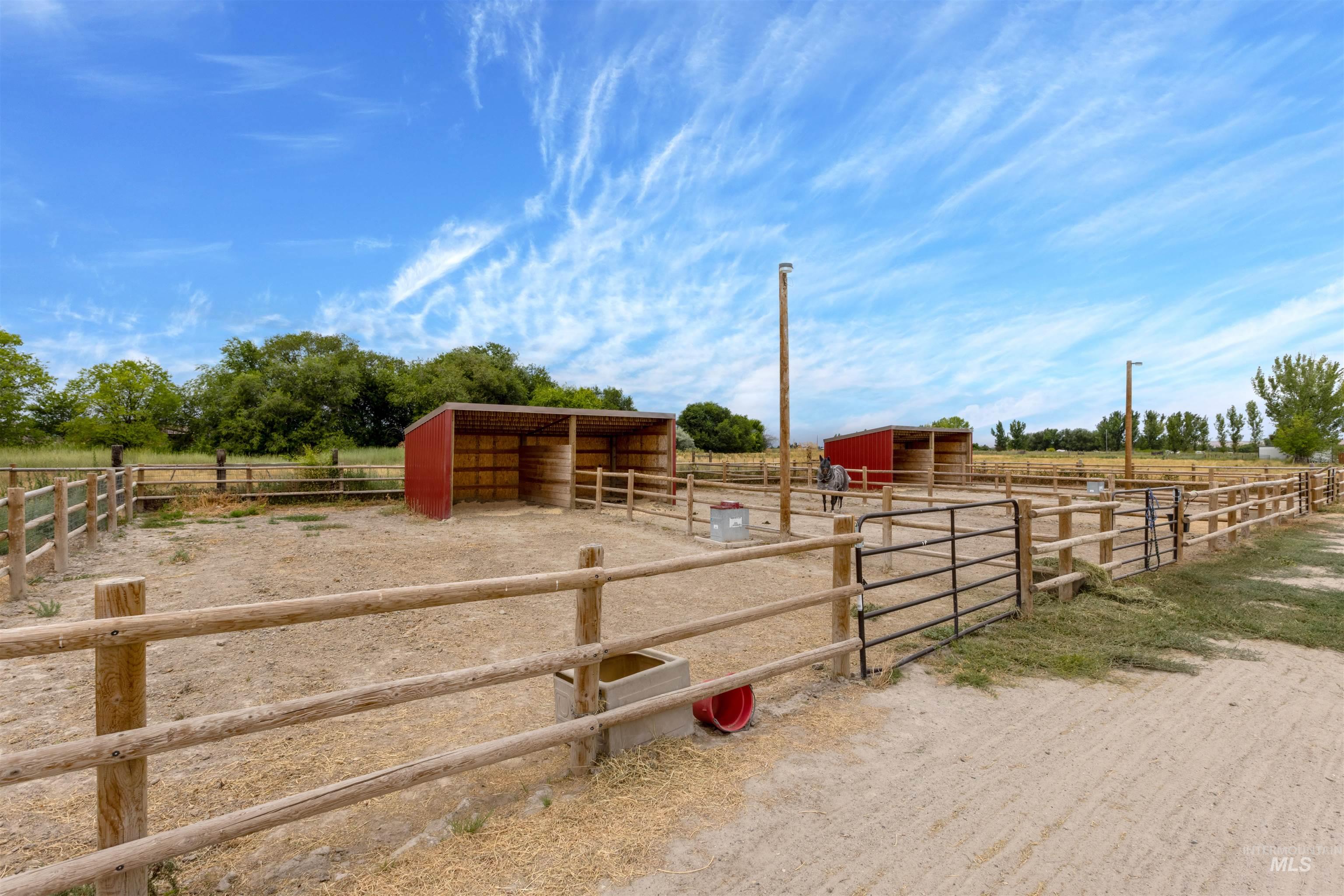 View of yard with an exterior structure, a rural view, an outbuilding, and driveway