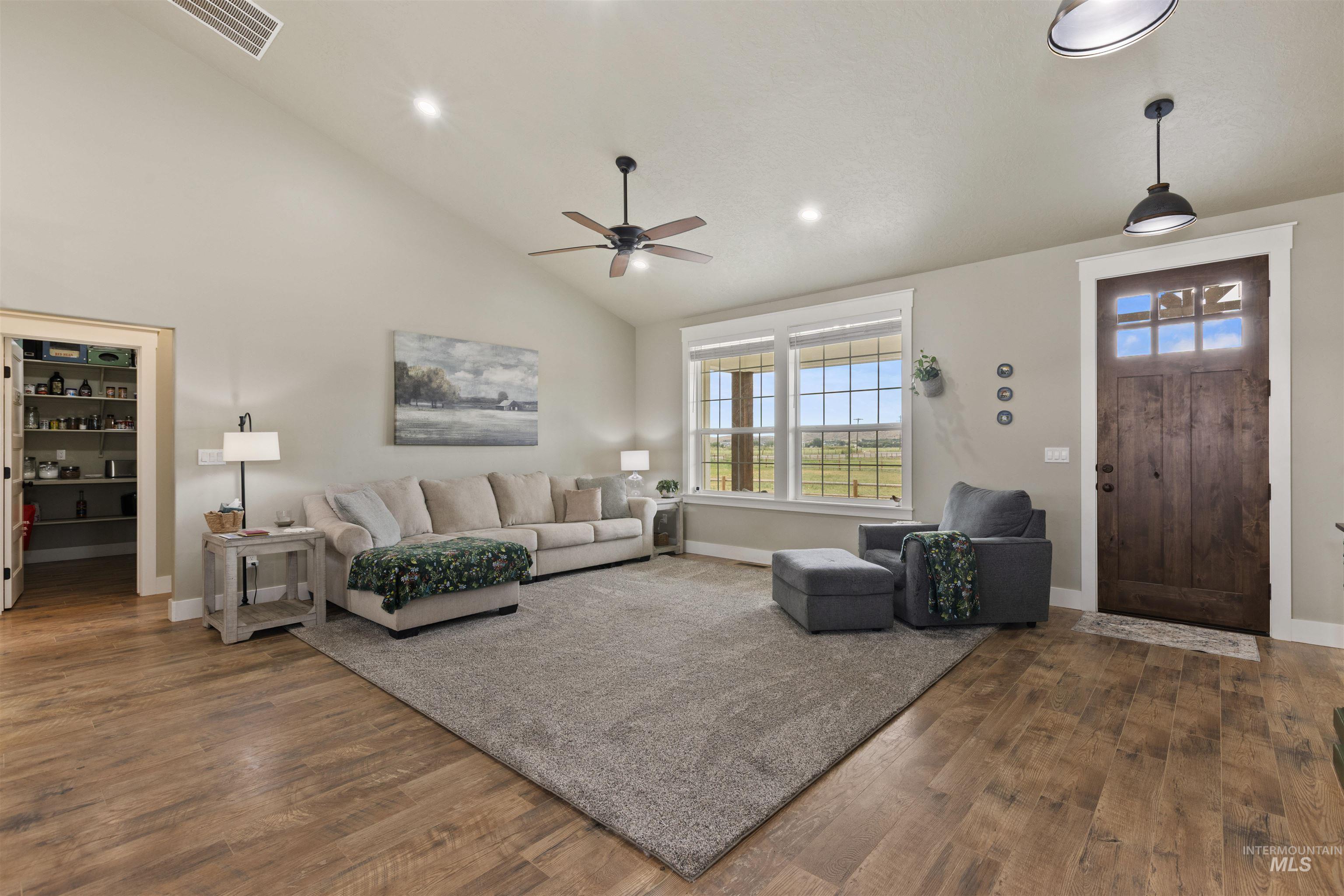 Living area featuring a ceiling fan, wood finished floors, lofted ceiling, and recessed lighting