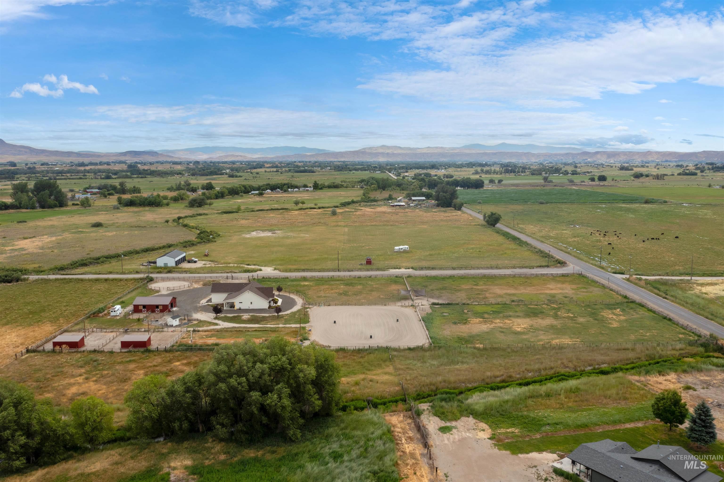 Overview of rural landscape featuring a pastoral area and a mountain backdrop