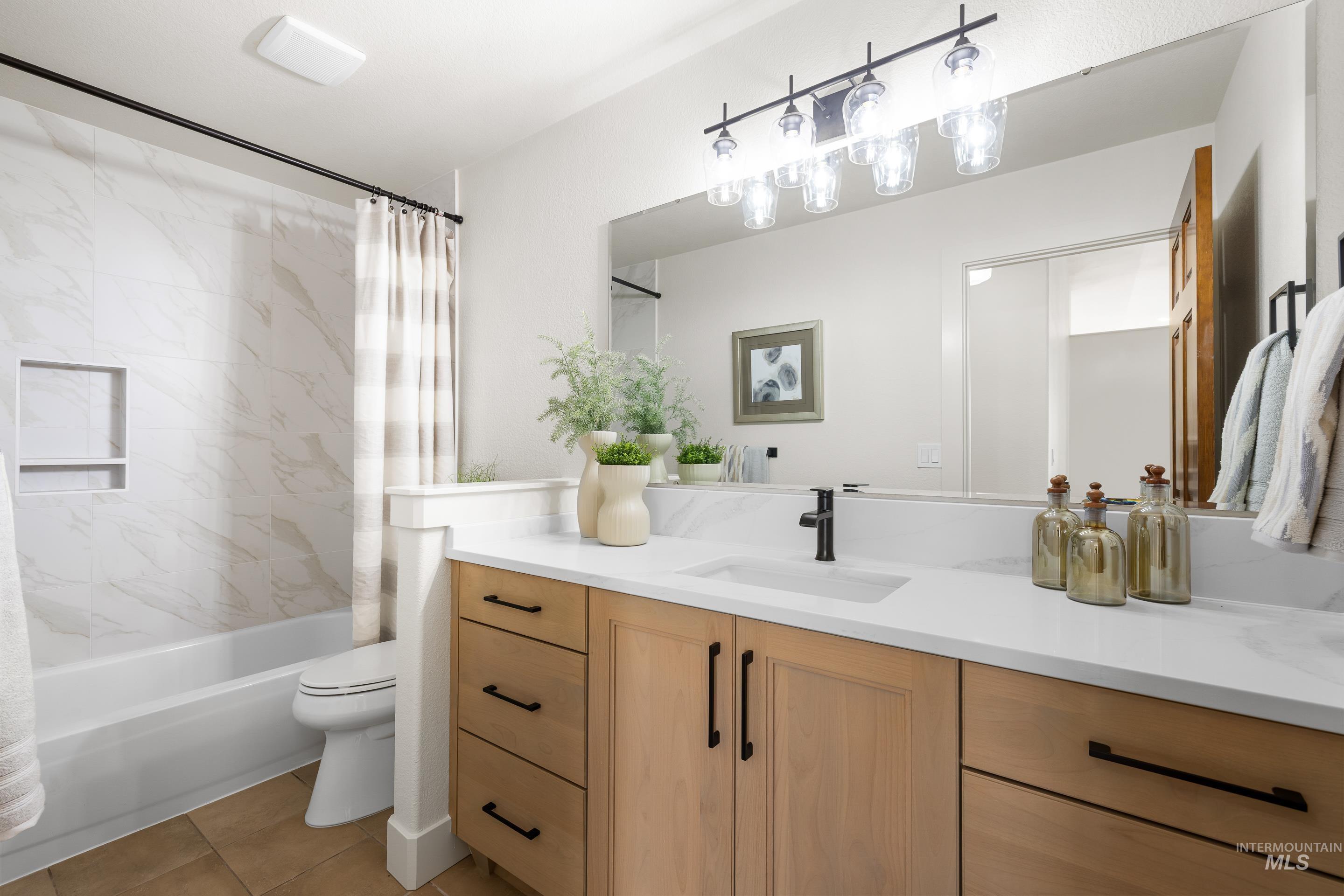 Bathroom with shower / bath combination with curtain, vanity, and light tile patterned floors