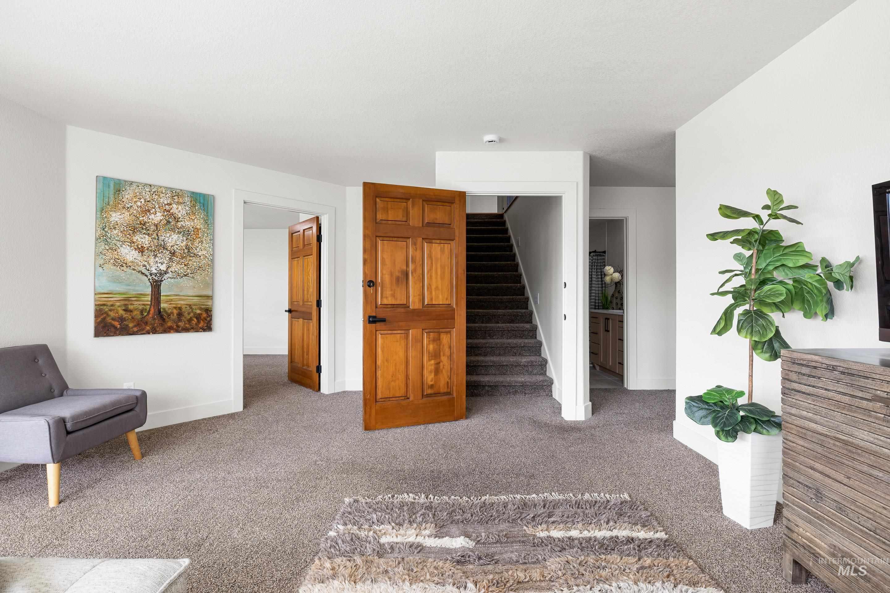 Living area with carpet floors and stairway