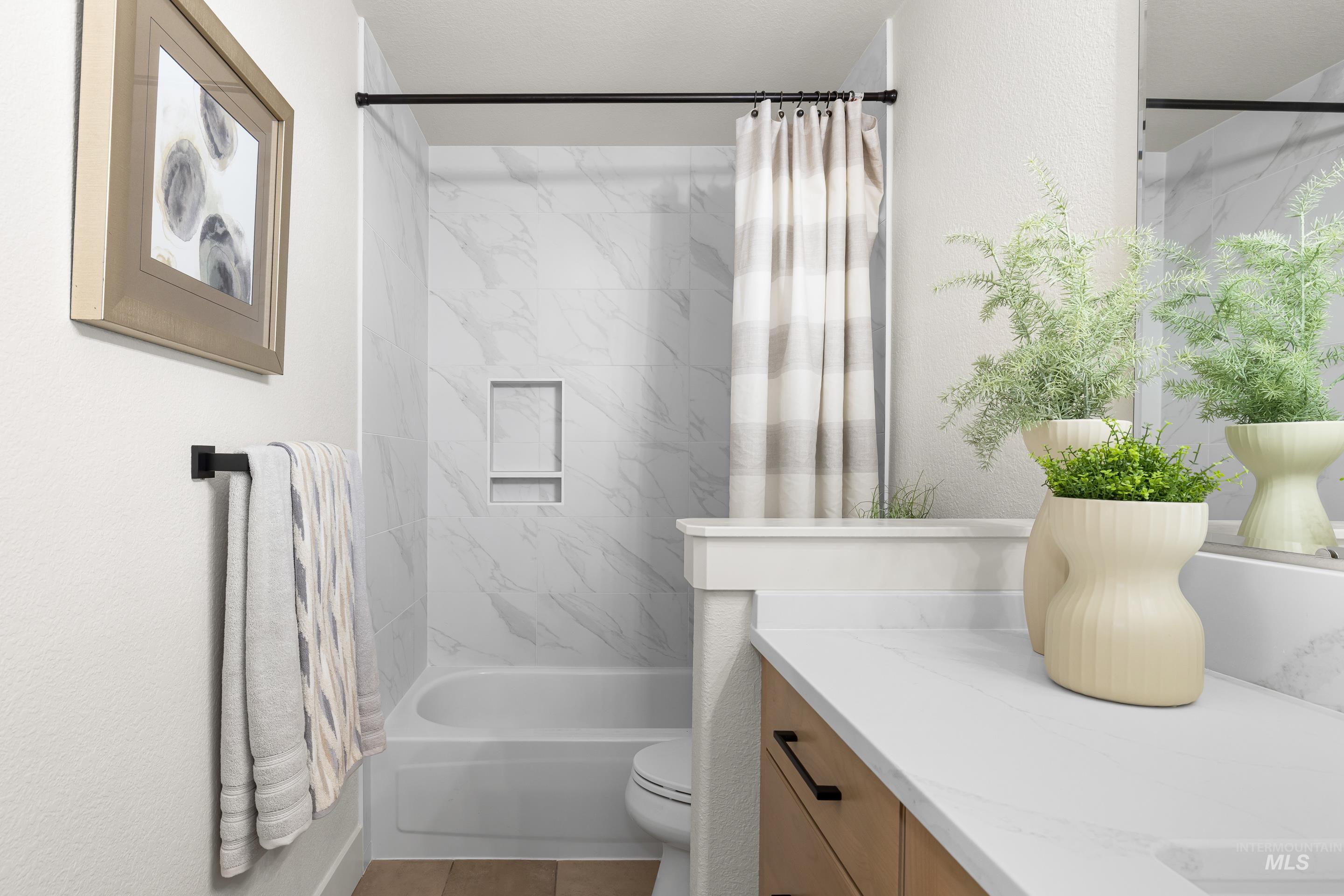Full bathroom featuring shower / bath combo with shower curtain, vanity, and tile patterned floors