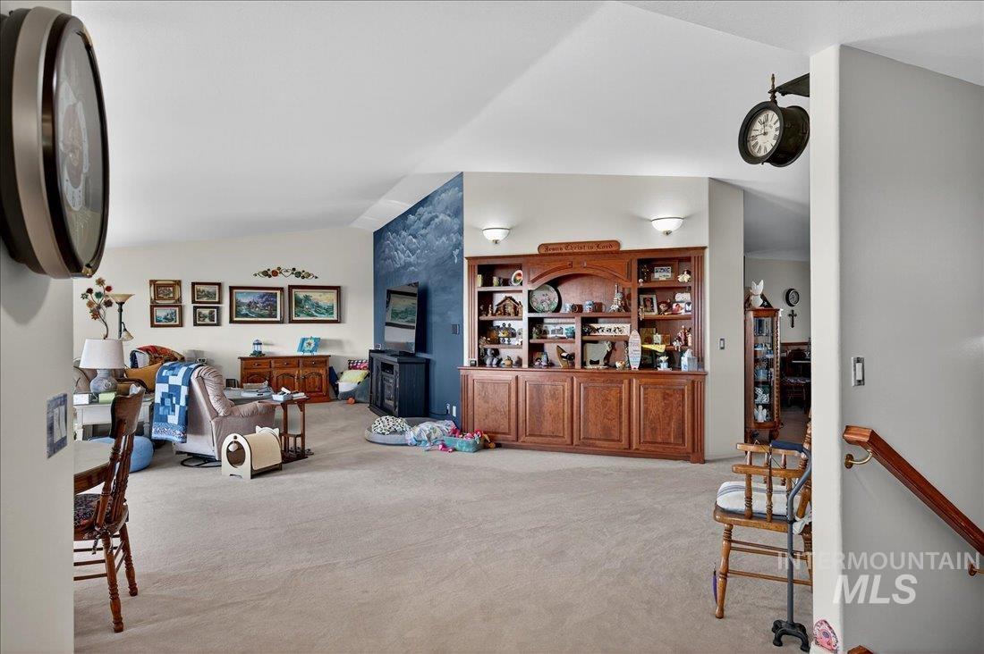 Additional living space featuring light carpet and lofted ceiling