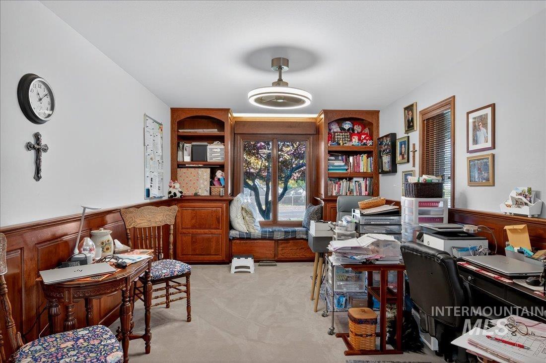 Office space with light colored carpet and wainscoting