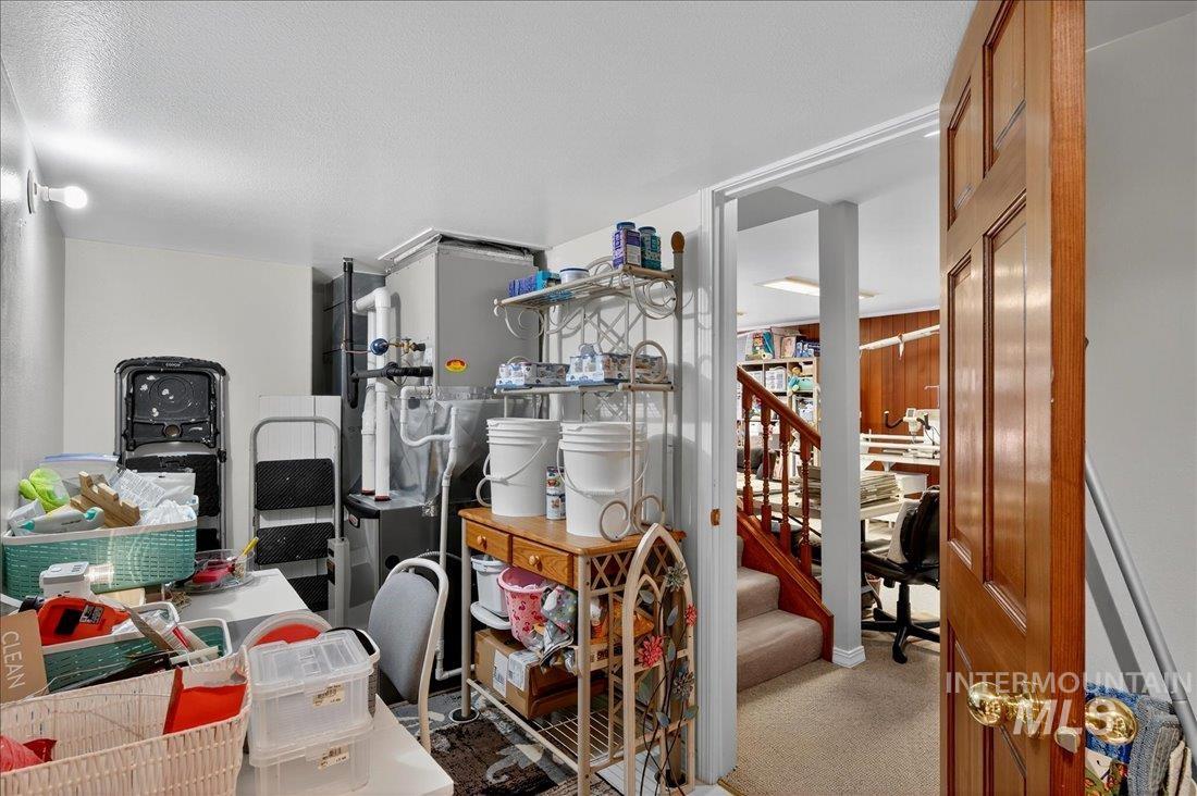 Office space with carpet flooring, heating unit, and a textured ceiling