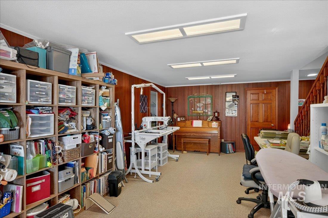 Home office featuring wood walls and light colored carpet