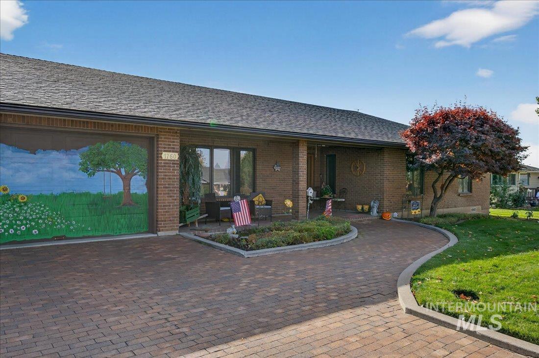 View of front of home featuring brick siding, a shingled roof, and a front yard