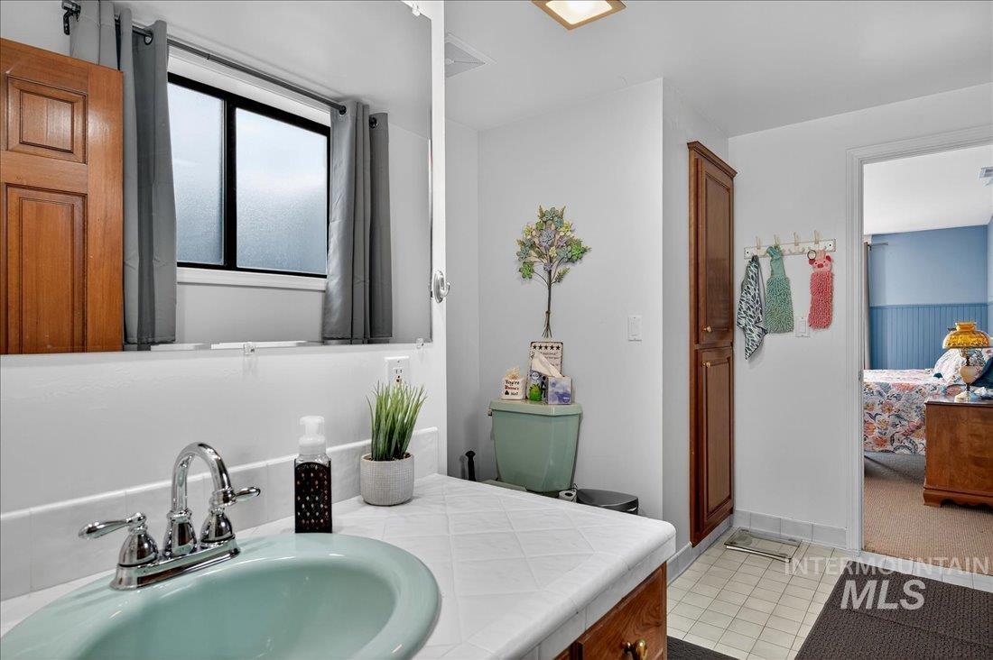 Bathroom with ensuite bathroom, vanity, and light tile patterned floors