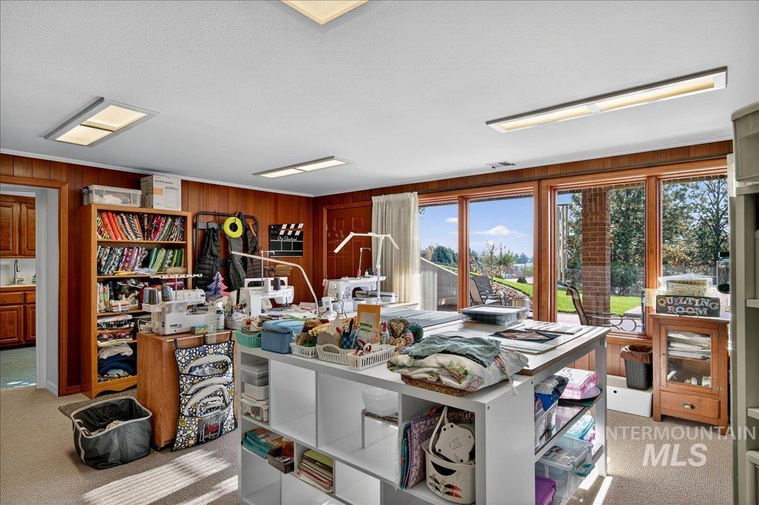 Office area with light carpet and wooden walls