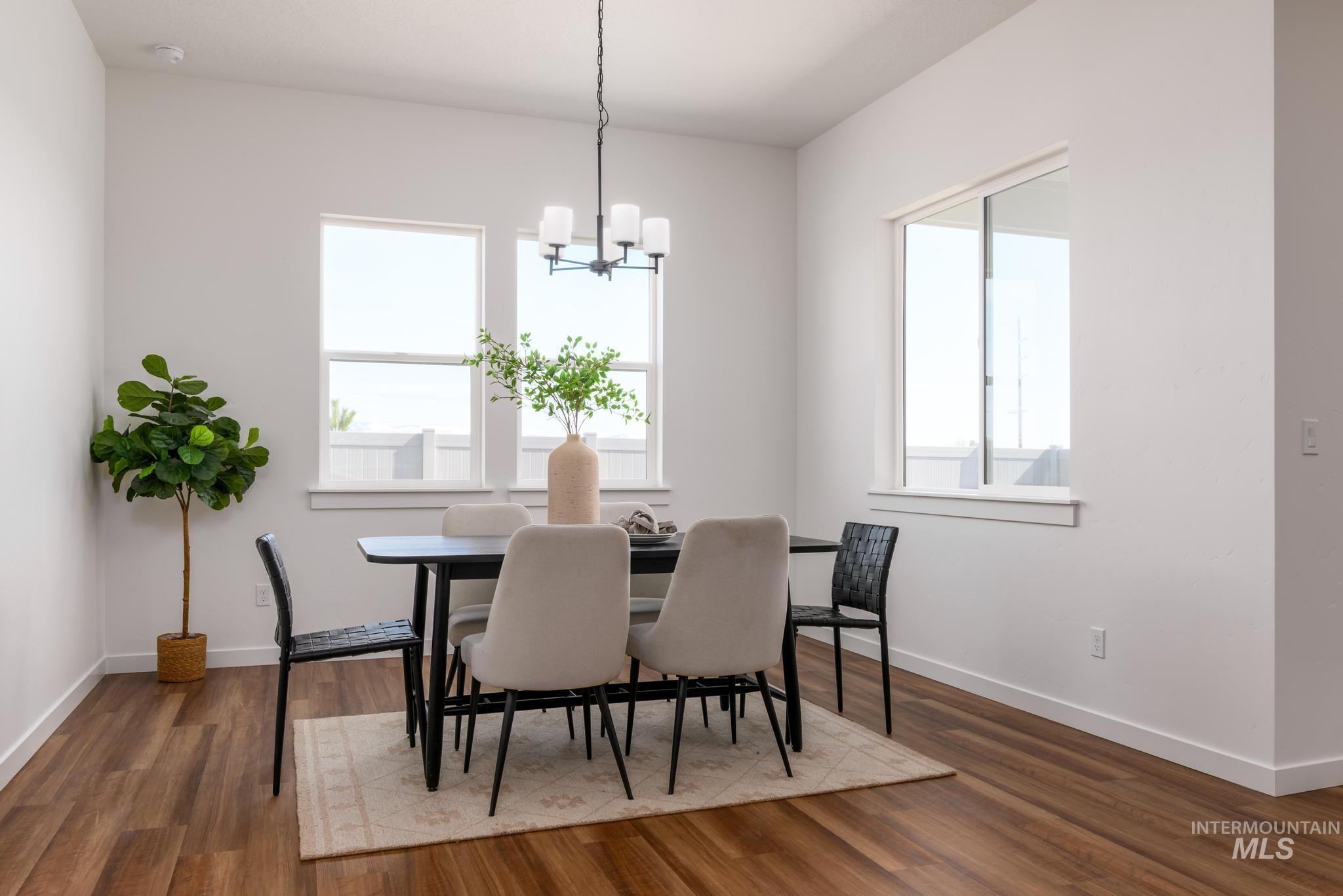 Dining space with a chandelier and dark wood-style flooring