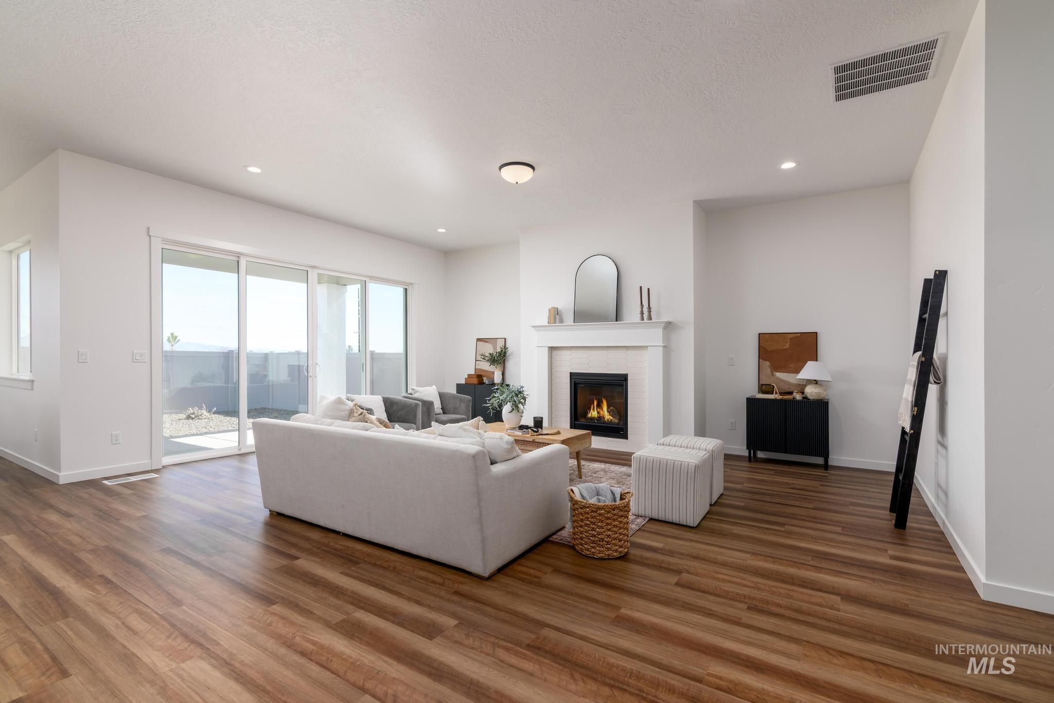 Living room featuring a fireplace, dark wood finished floors, and recessed lighting