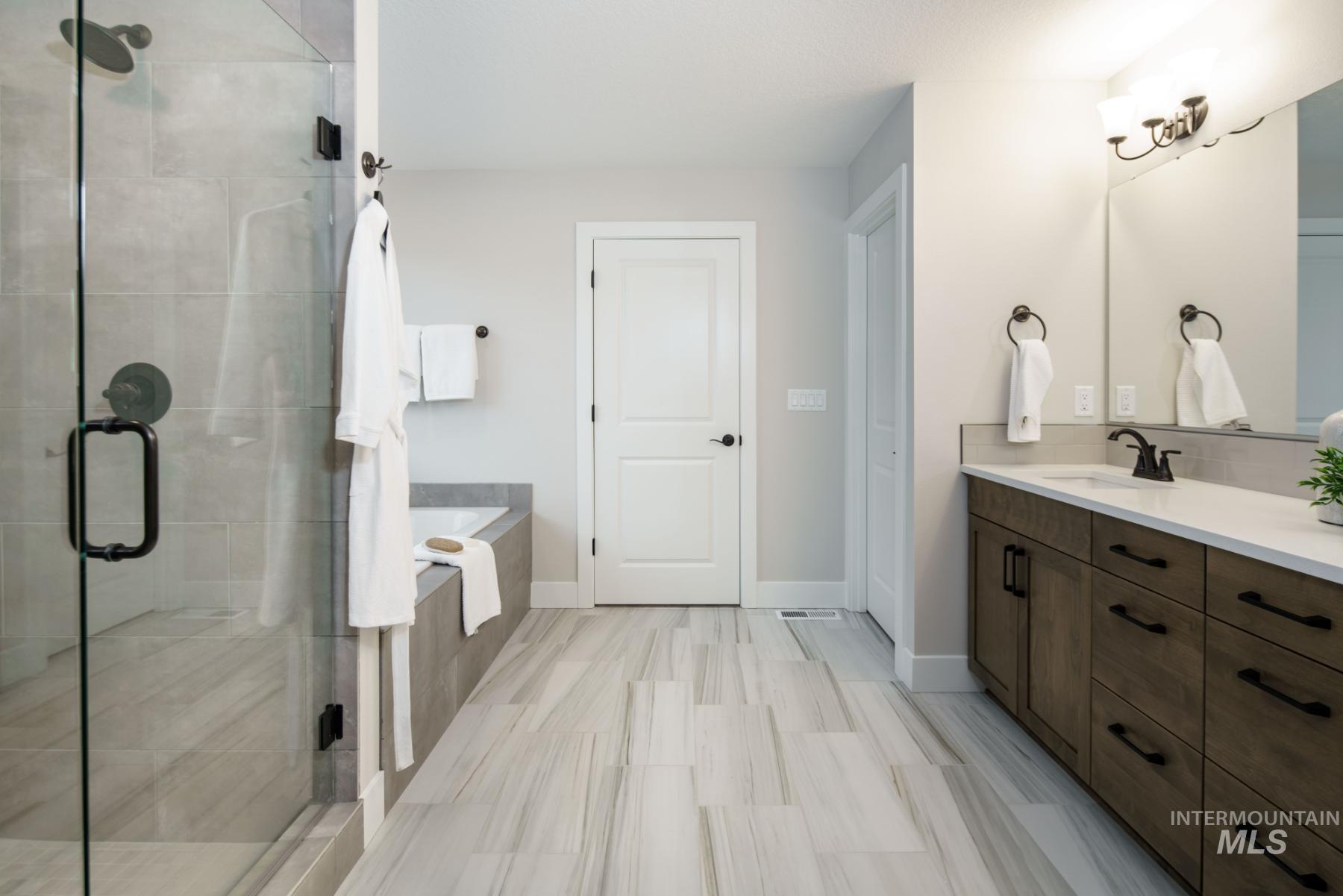 Bathroom featuring vanity, a shower stall, and a garden tub