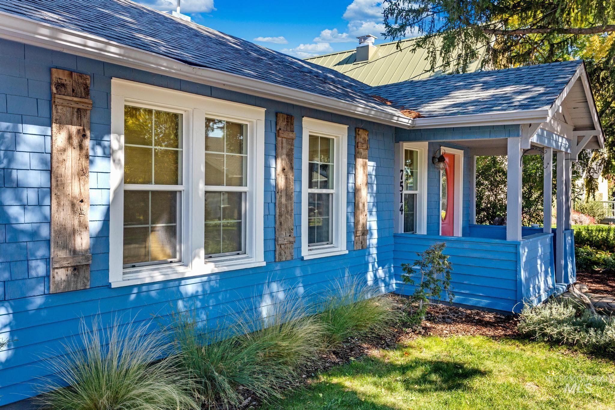 View of home's exterior featuring a porch, roof with shingles, and a chimney