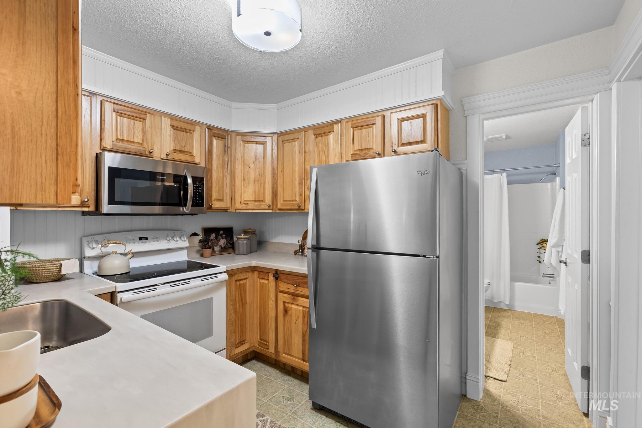 Kitchen featuring appliances with stainless steel finishes and a textured ceiling
