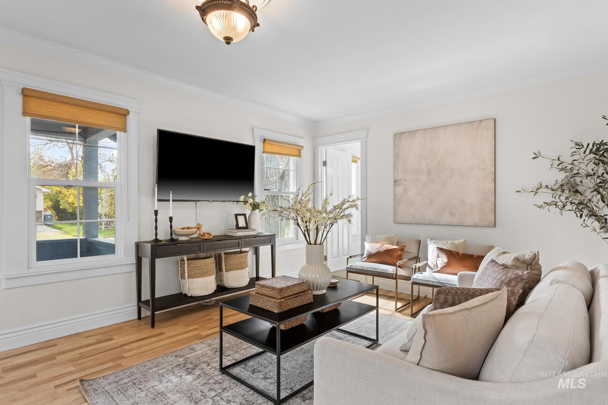 Living area featuring wood finished floors and crown molding